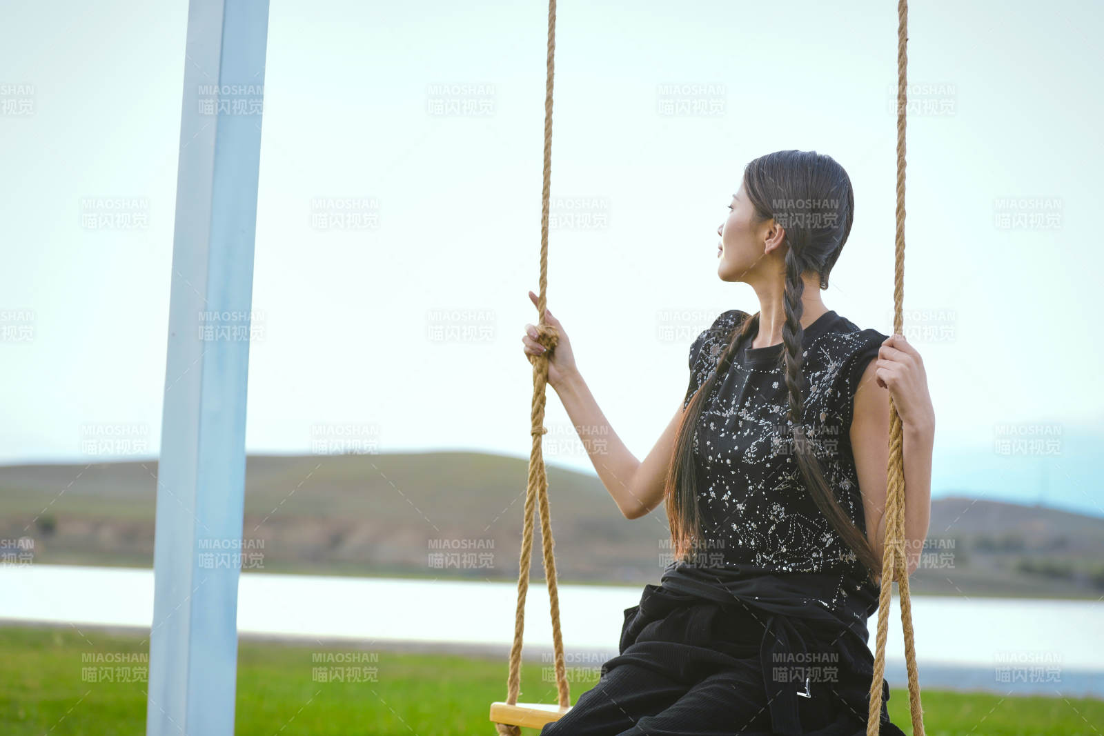 草原湖畔夕陽(yáng)下蕩秋千的亞洲少女