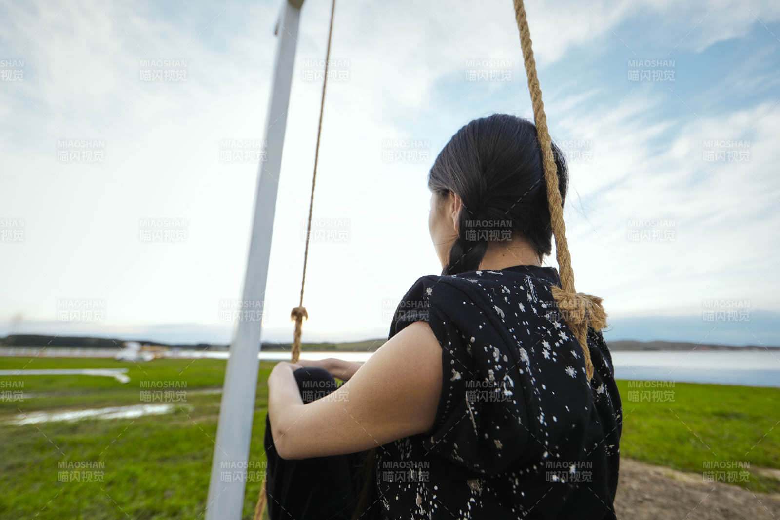 草原湖畔夕陽下蕩秋千的亞洲少女