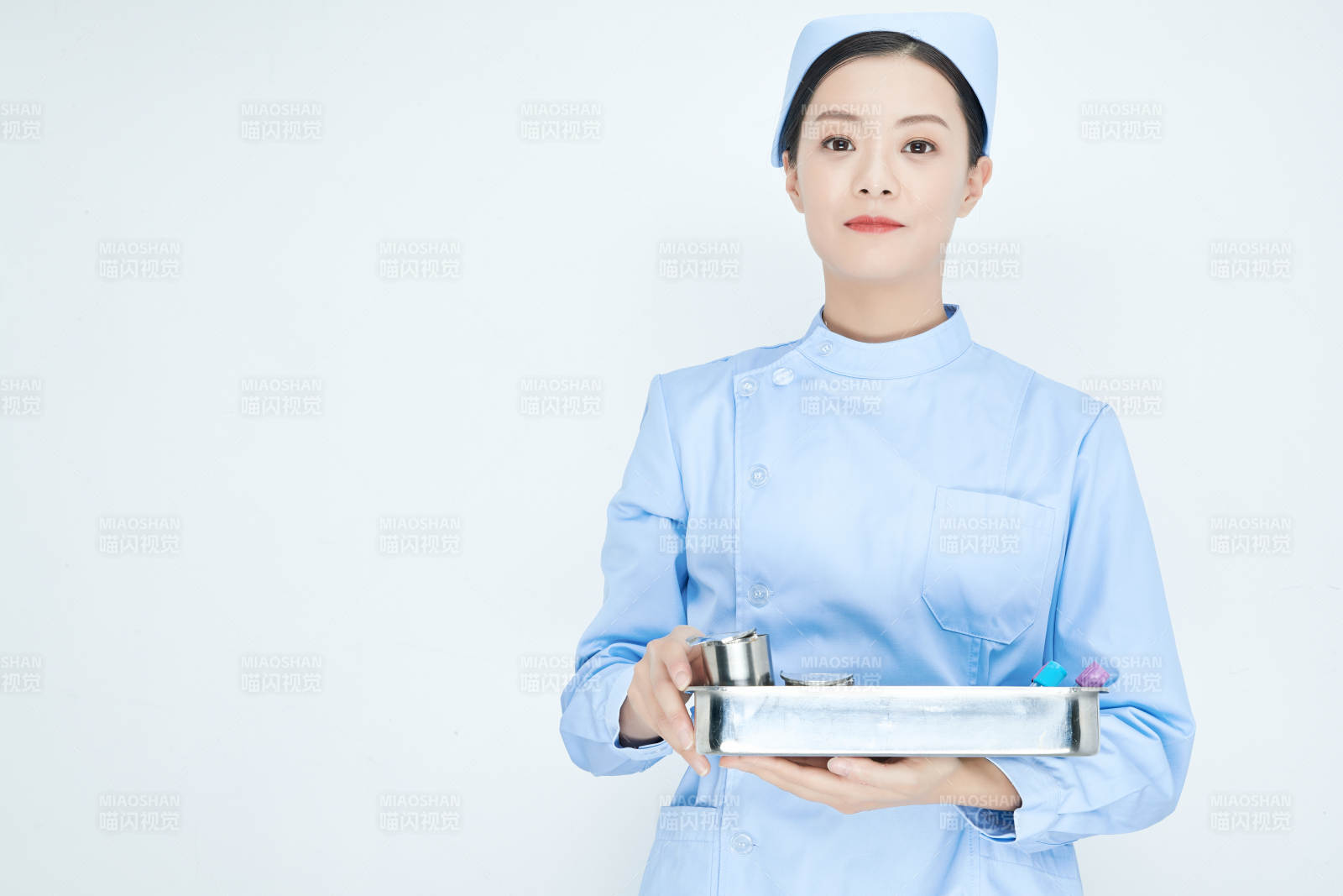 身穿護士服手抱化驗托盤的年輕女護士