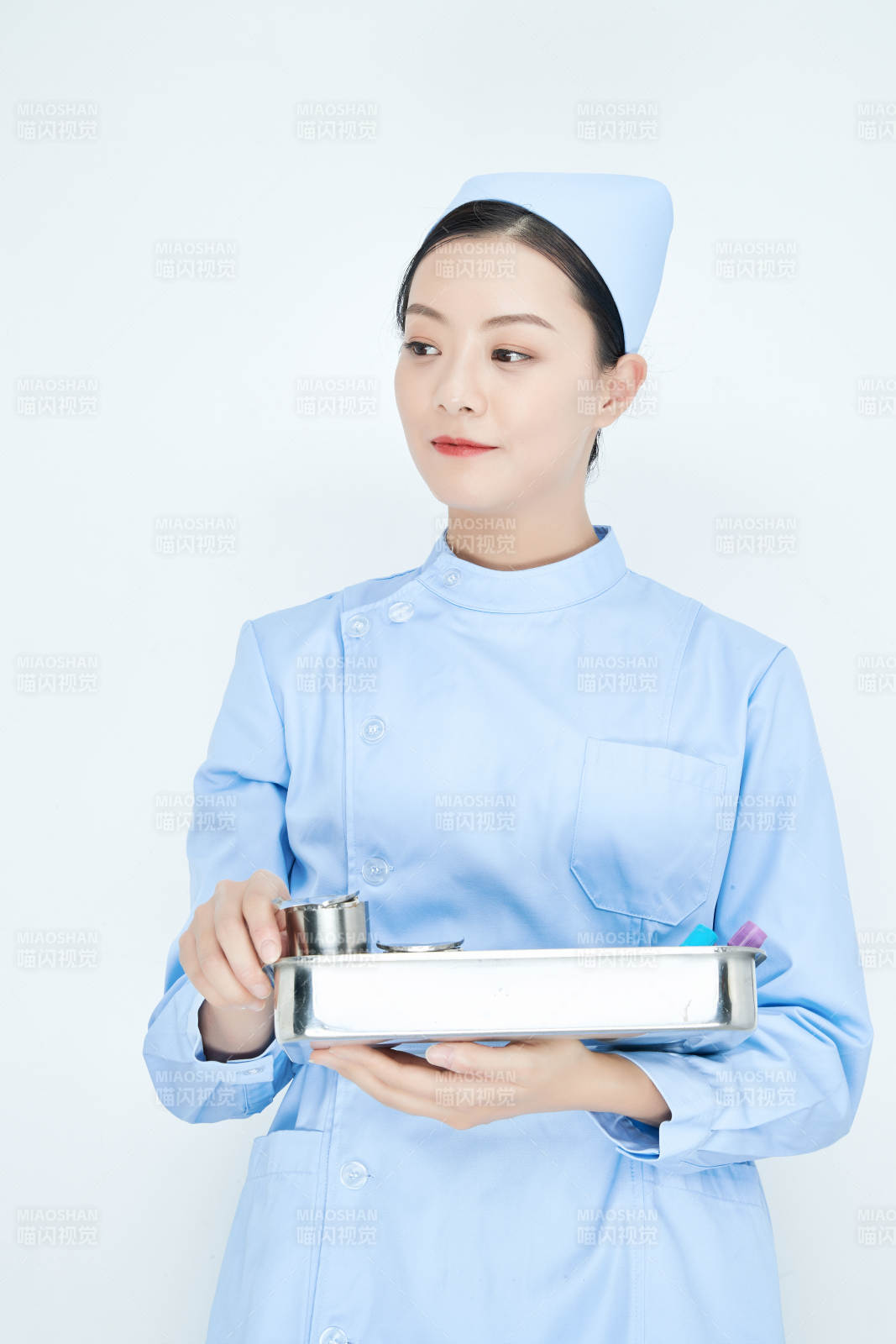 身穿護士服手抱化驗托盤的年輕女護士
