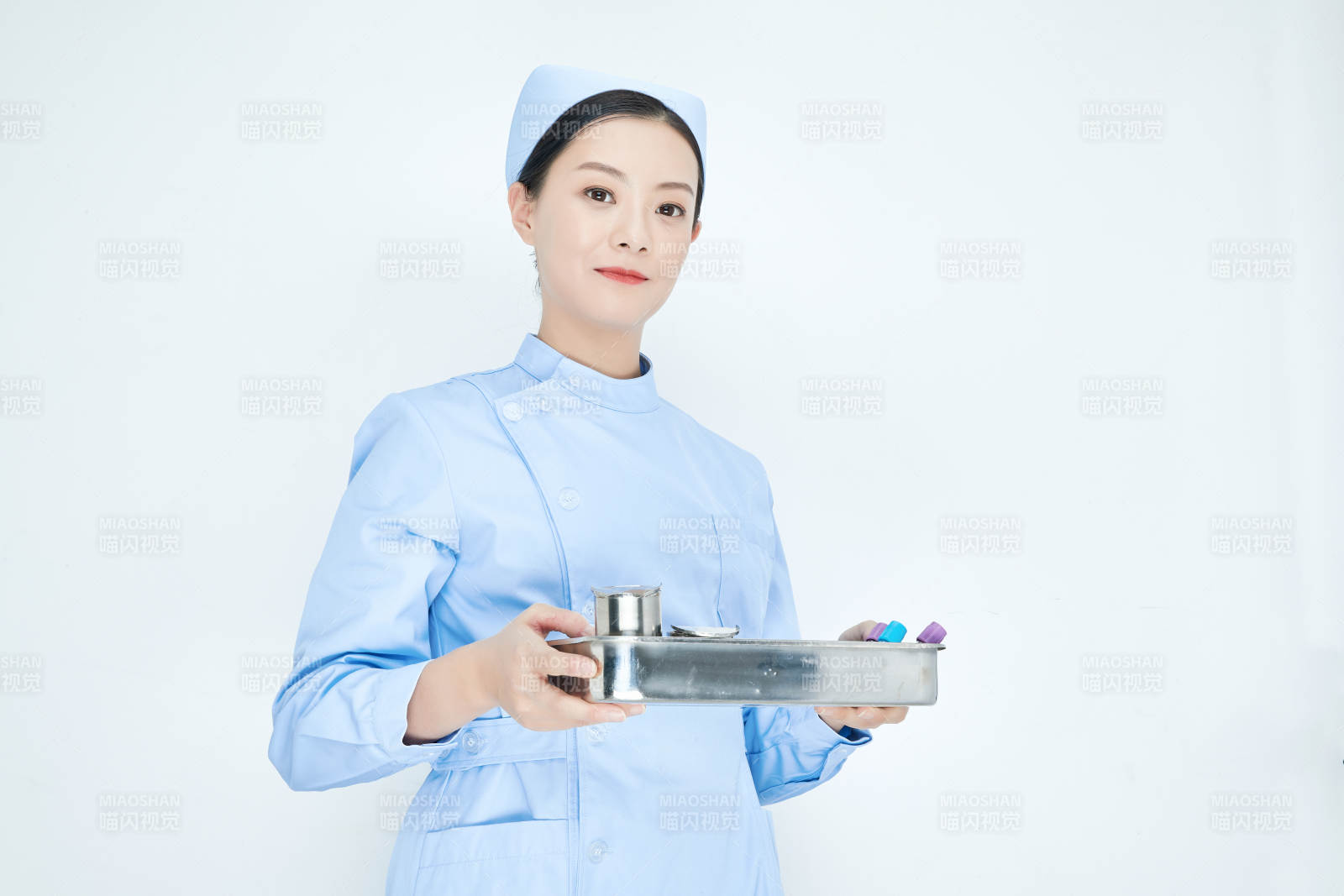 身穿護士服手抱化驗托盤的年輕女護士