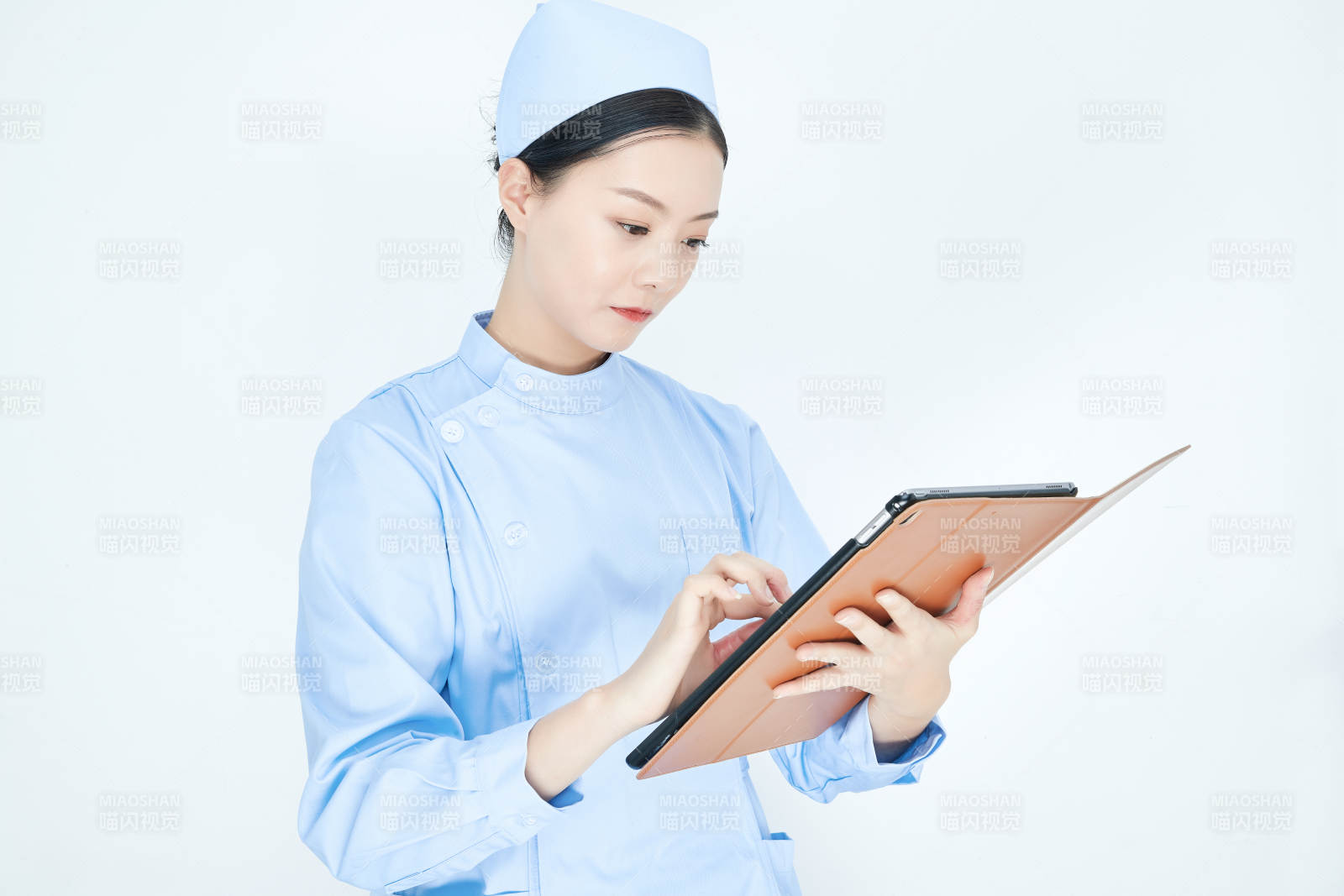 身穿護(hù)士服手拿醫(yī)用iPad的年輕護(hù)士