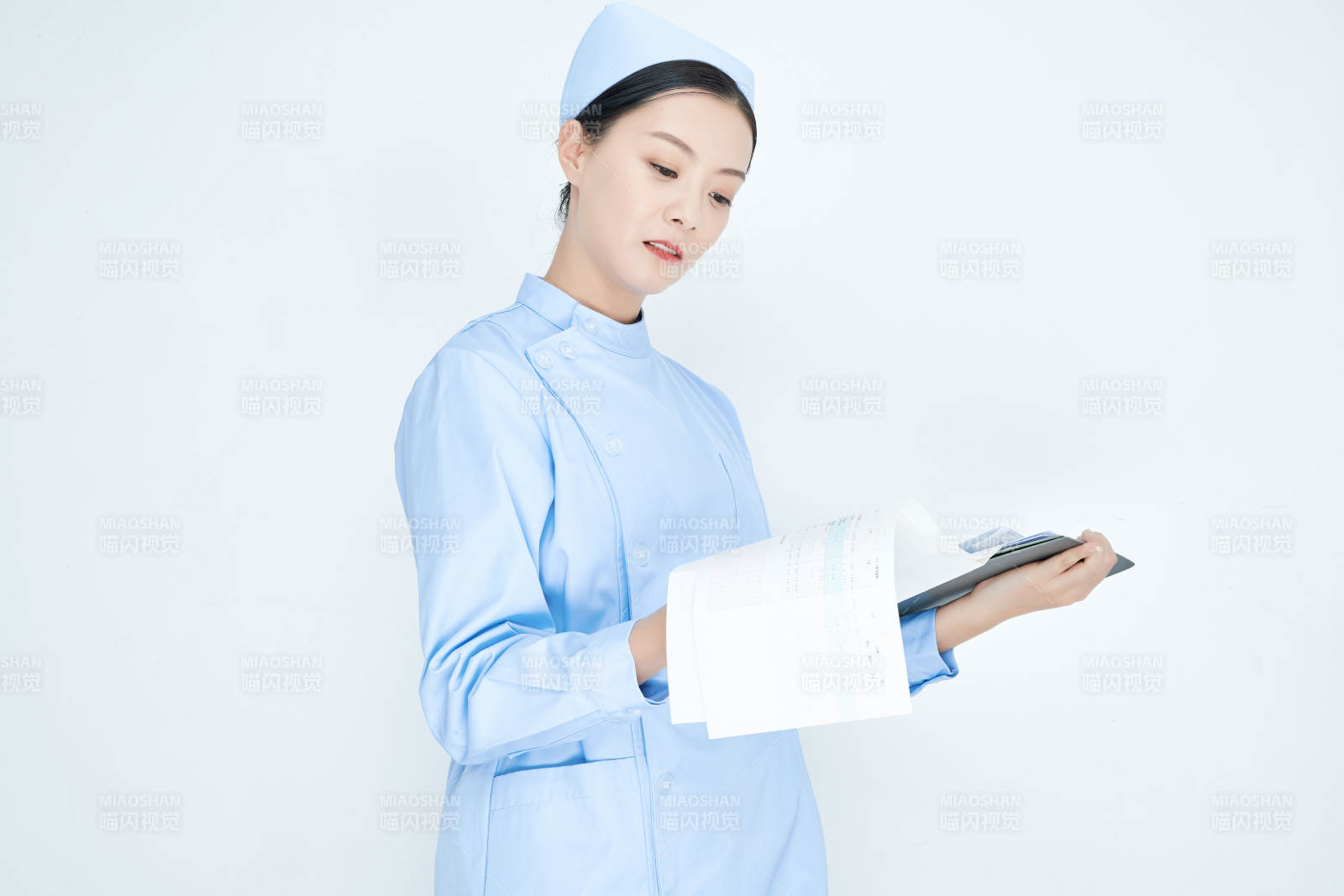 白背景里穿藍(lán)色護士服手持病歷夾的美女護士