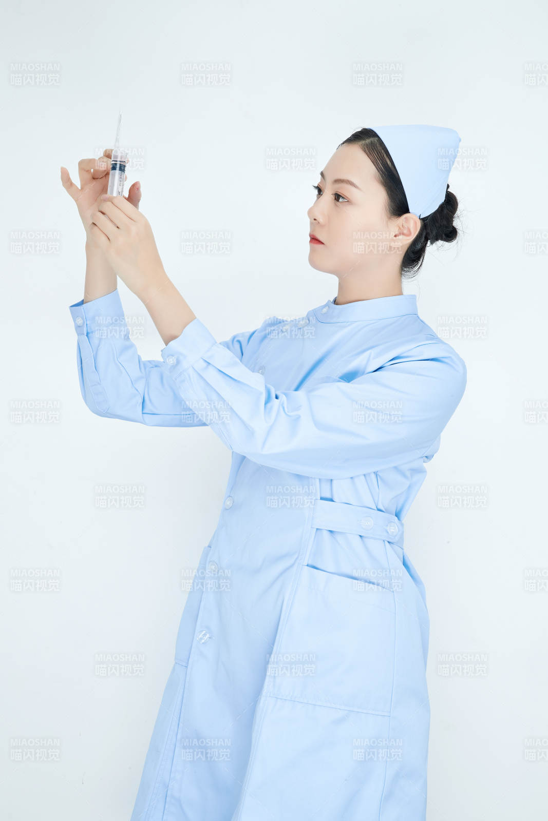 穿護(hù)士服戴口罩手執(zhí)針筒的年輕女護(hù)士