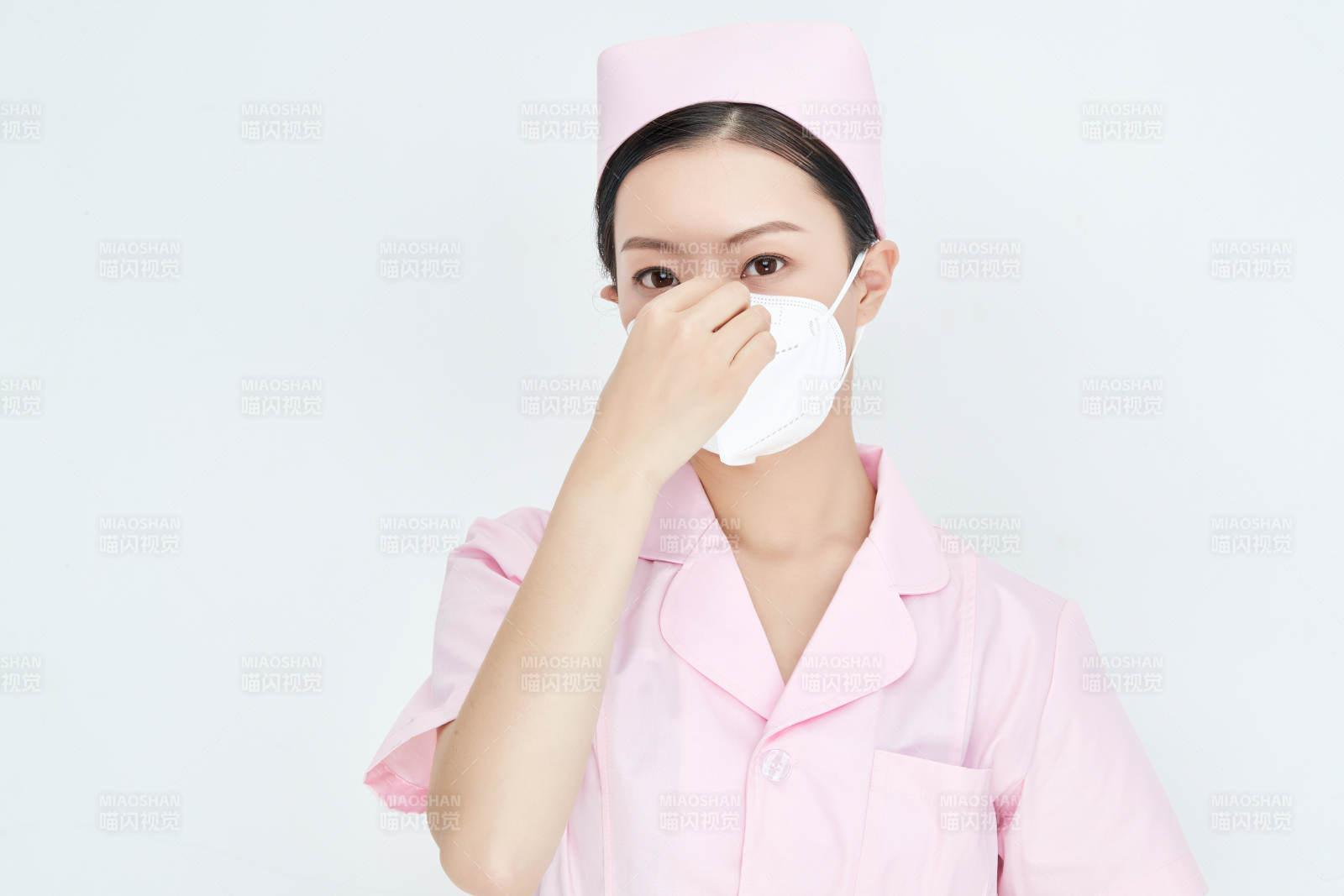 女性醫(yī)護人員展示規(guī)范的口罩正確佩戴方式