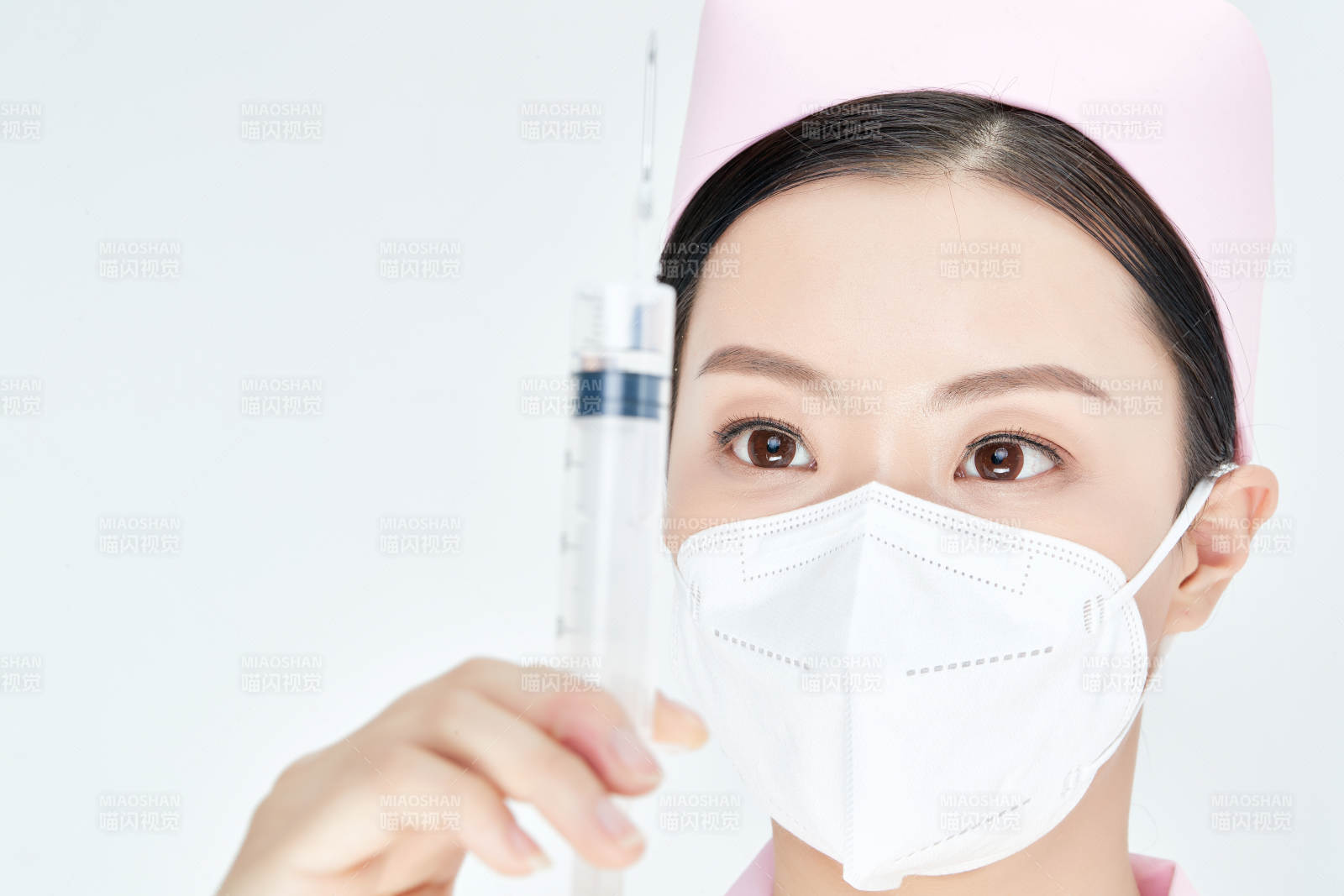 穿護士服戴口罩手執(zhí)針筒的年輕女護士
