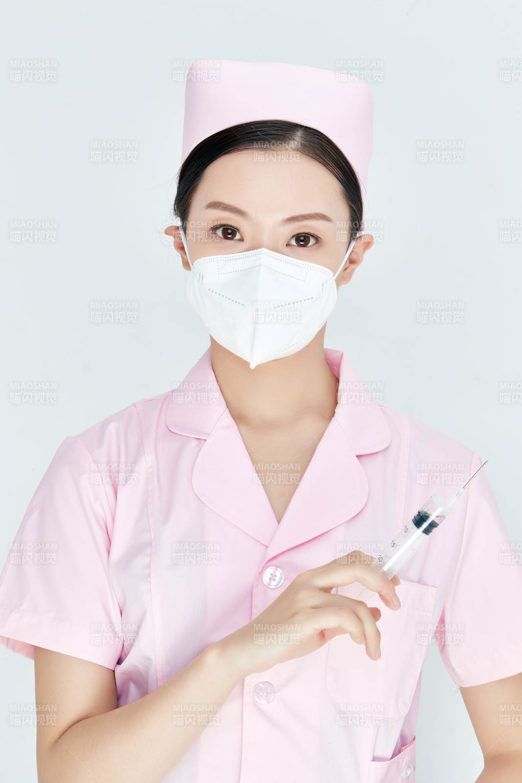 穿護(hù)士服戴口罩手執(zhí)針筒的年輕女護(hù)士