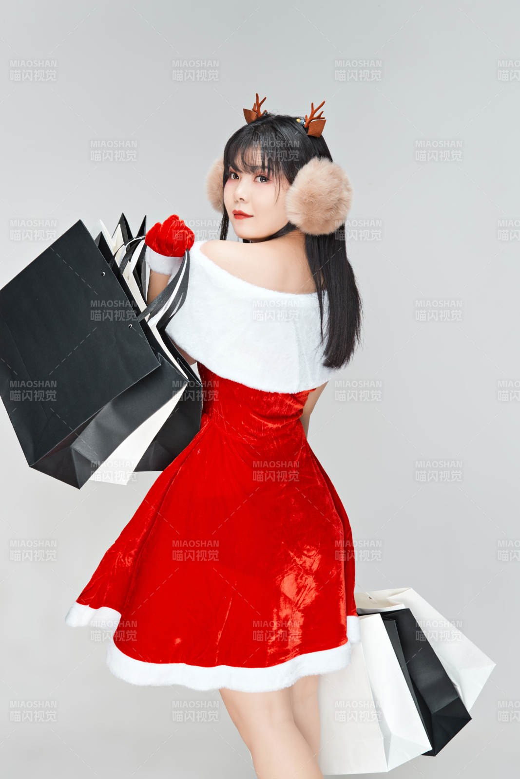 身穿圣誕服飾手提購物袋性感可愛的圣誕女郎