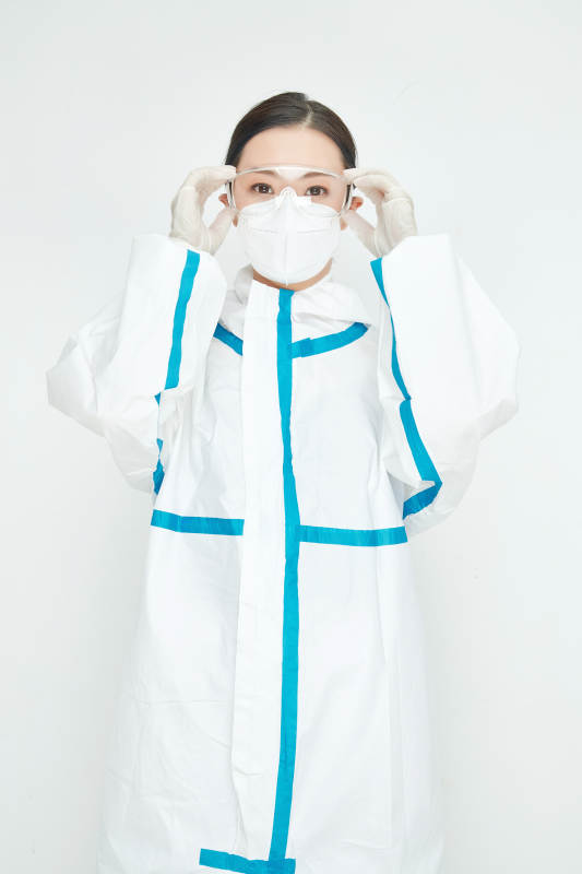 穿白色防护服佩戴护目镜口罩的女性医疗人员