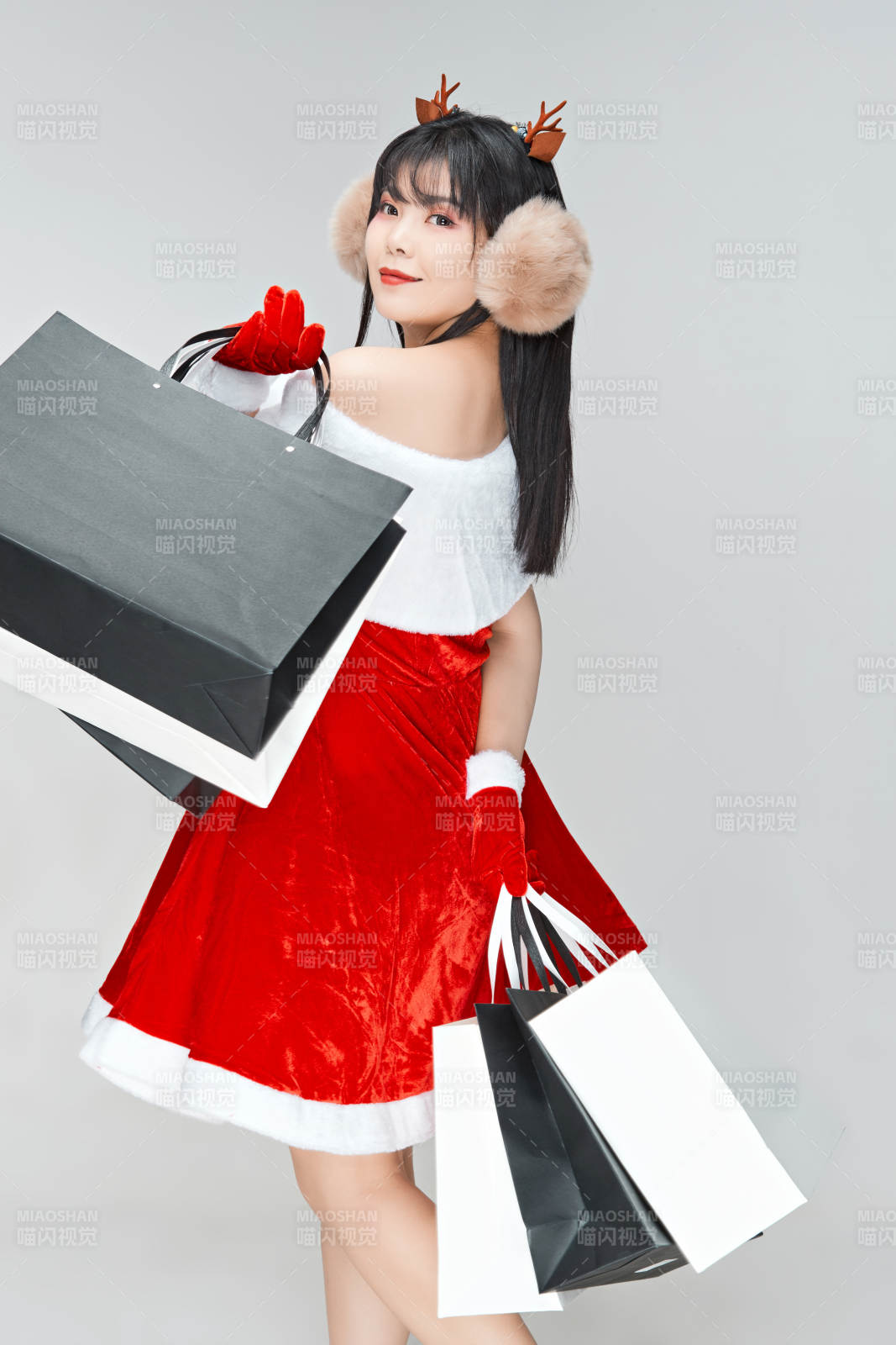 身穿圣誕服飾手提購物袋性感可愛的圣誕女郎