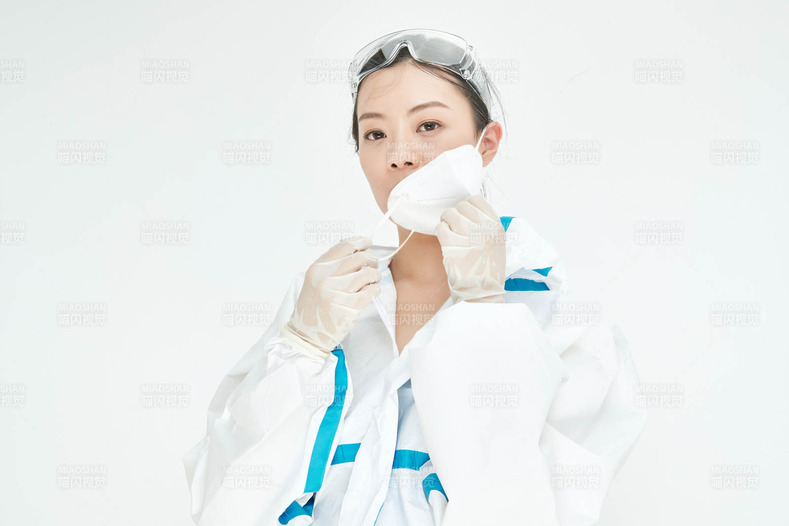 穿白色防护服佩戴护目镜口罩的女性医疗人员