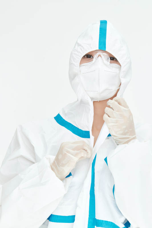 穿白色防护服佩戴护目镜口罩的女性医疗人员