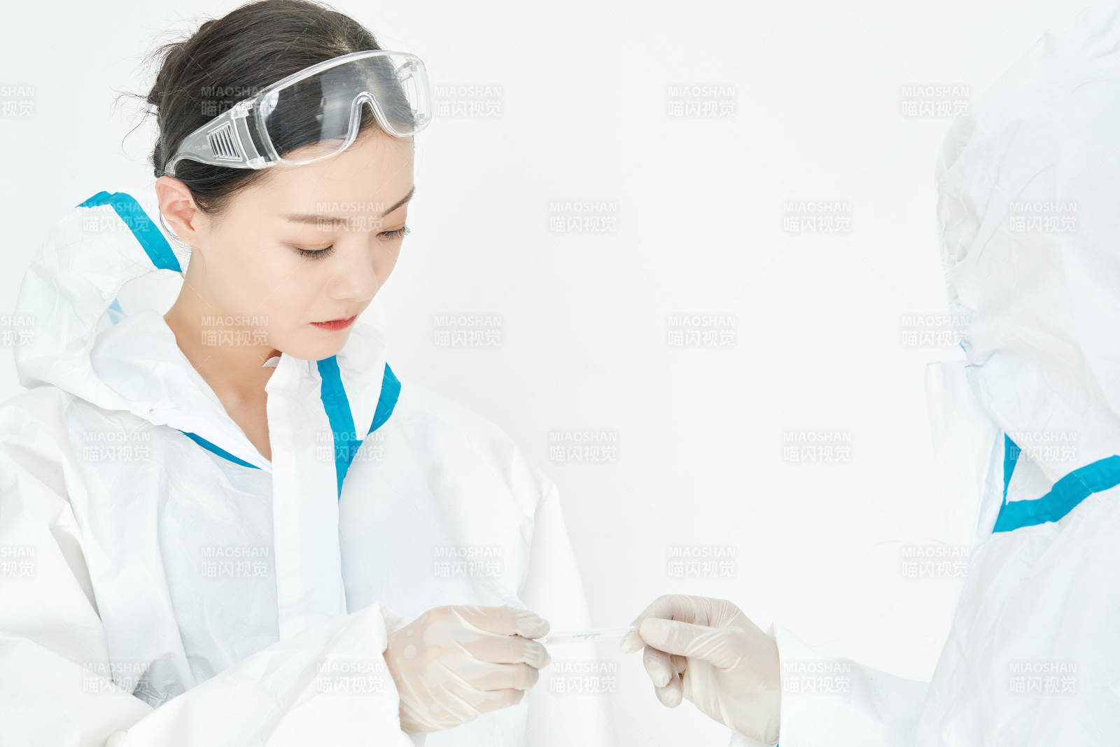 穿白色防護(hù)服佩戴護(hù)目鏡口罩的女性醫(yī)療人員