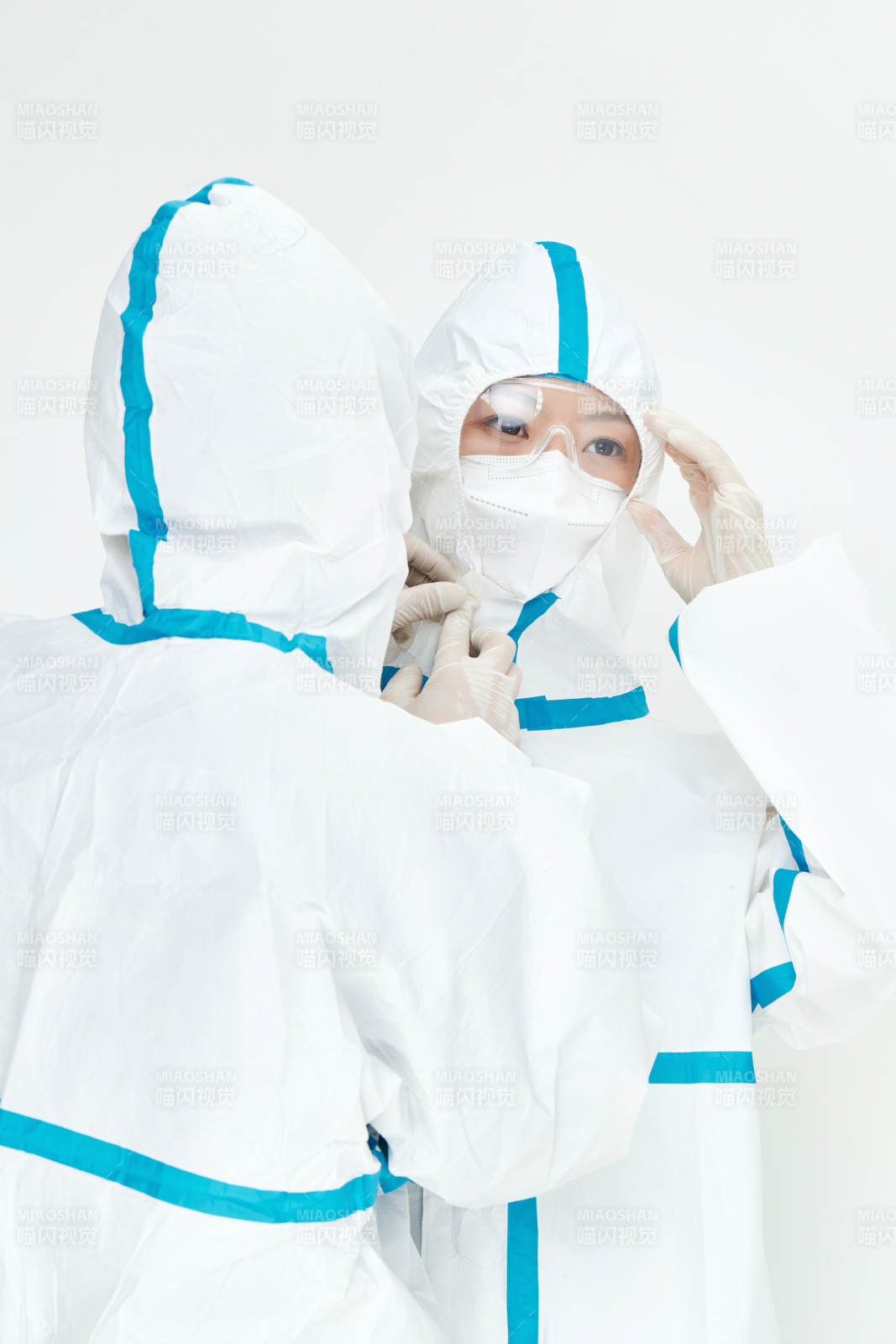 穿白色防護服佩戴護目鏡口罩的女性醫(yī)療人員
