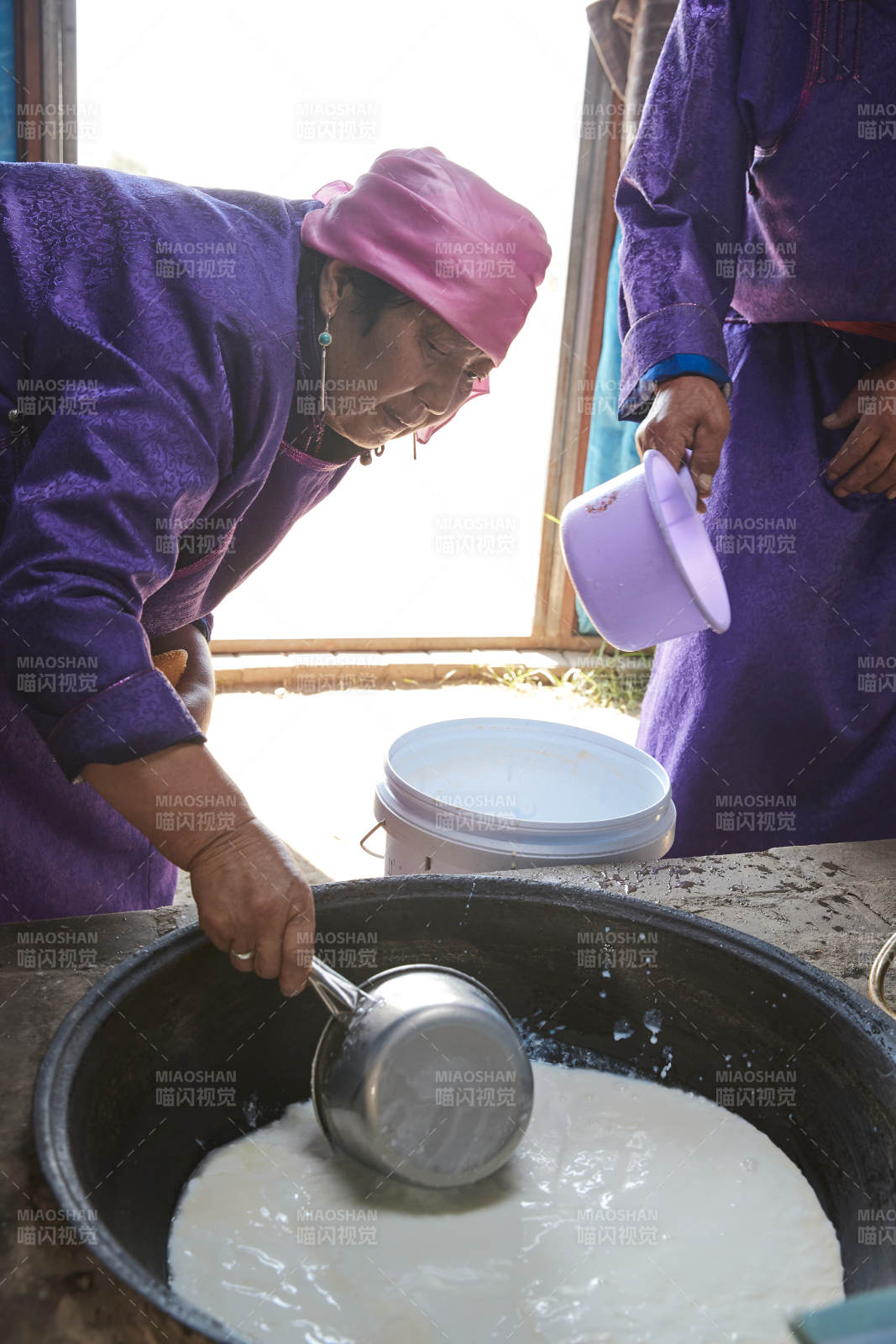 在蒙古包內用傳統工藝熬煮制作奶豆腐過程