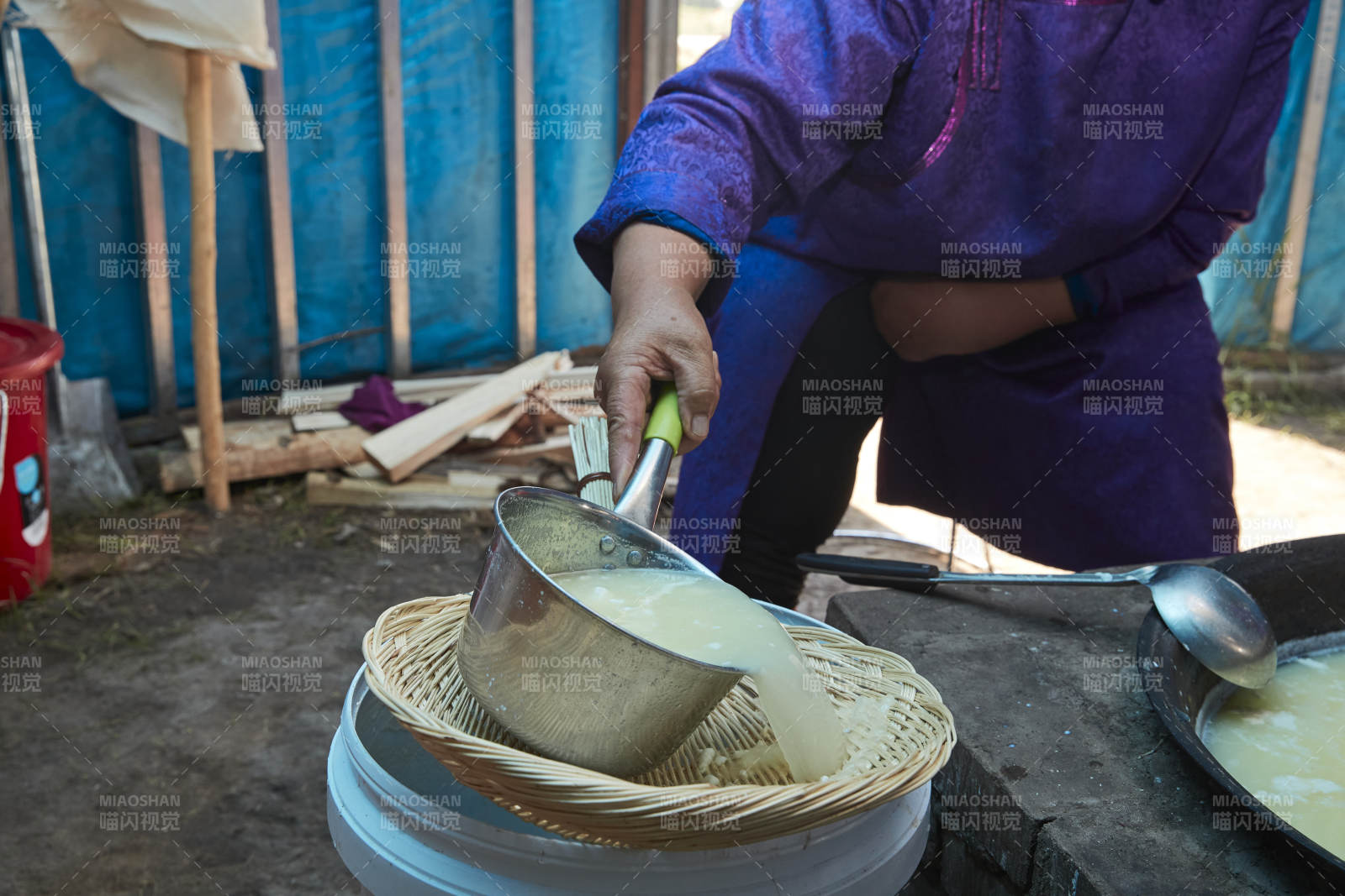 在蒙古包內(nèi)用傳統(tǒng)工藝熬煮制作奶豆腐過程