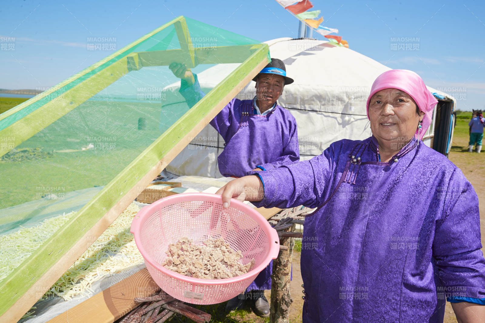 在蒙古包外晾曬奶制品的蒙古族中老年男性