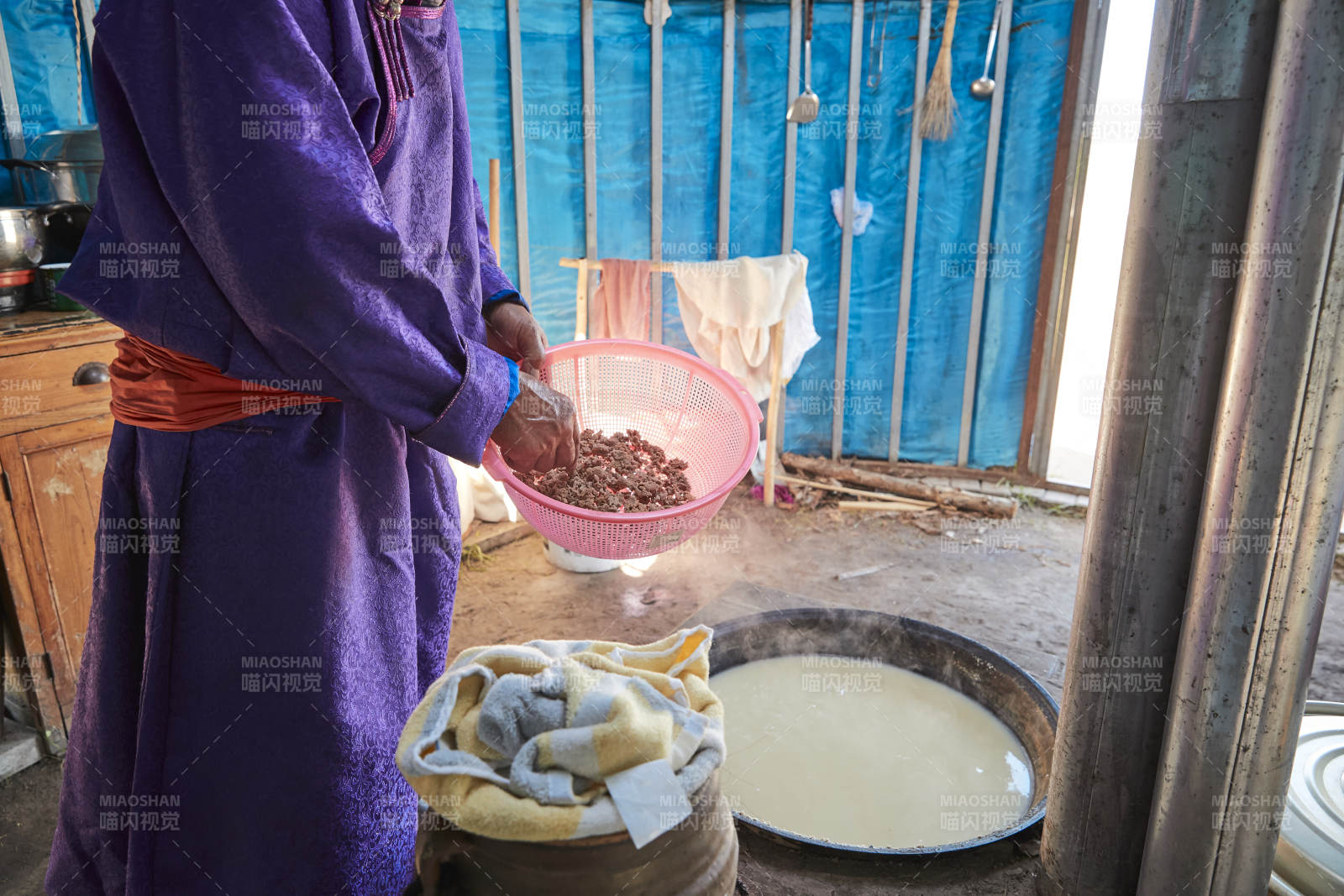 在蒙古包內用傳統工藝熬煮制作奶豆腐過程