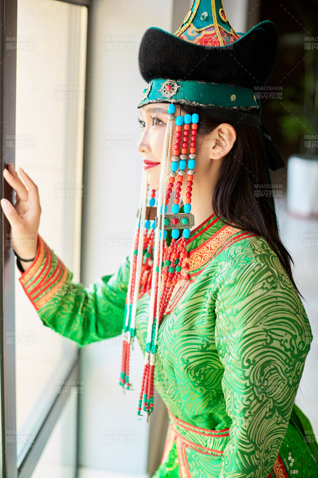 室內(nèi)穿著綠色蒙古袍的蒙古族年輕女性