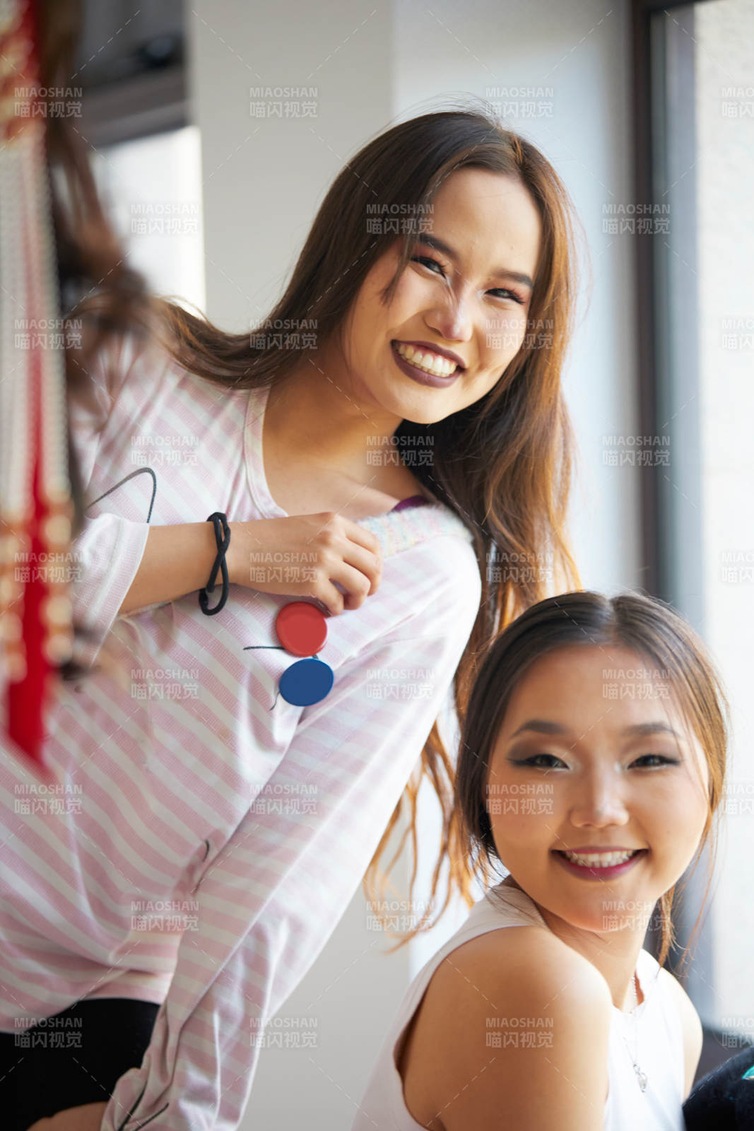 在室內兩位沖著鏡頭微笑的蒙古族姑娘