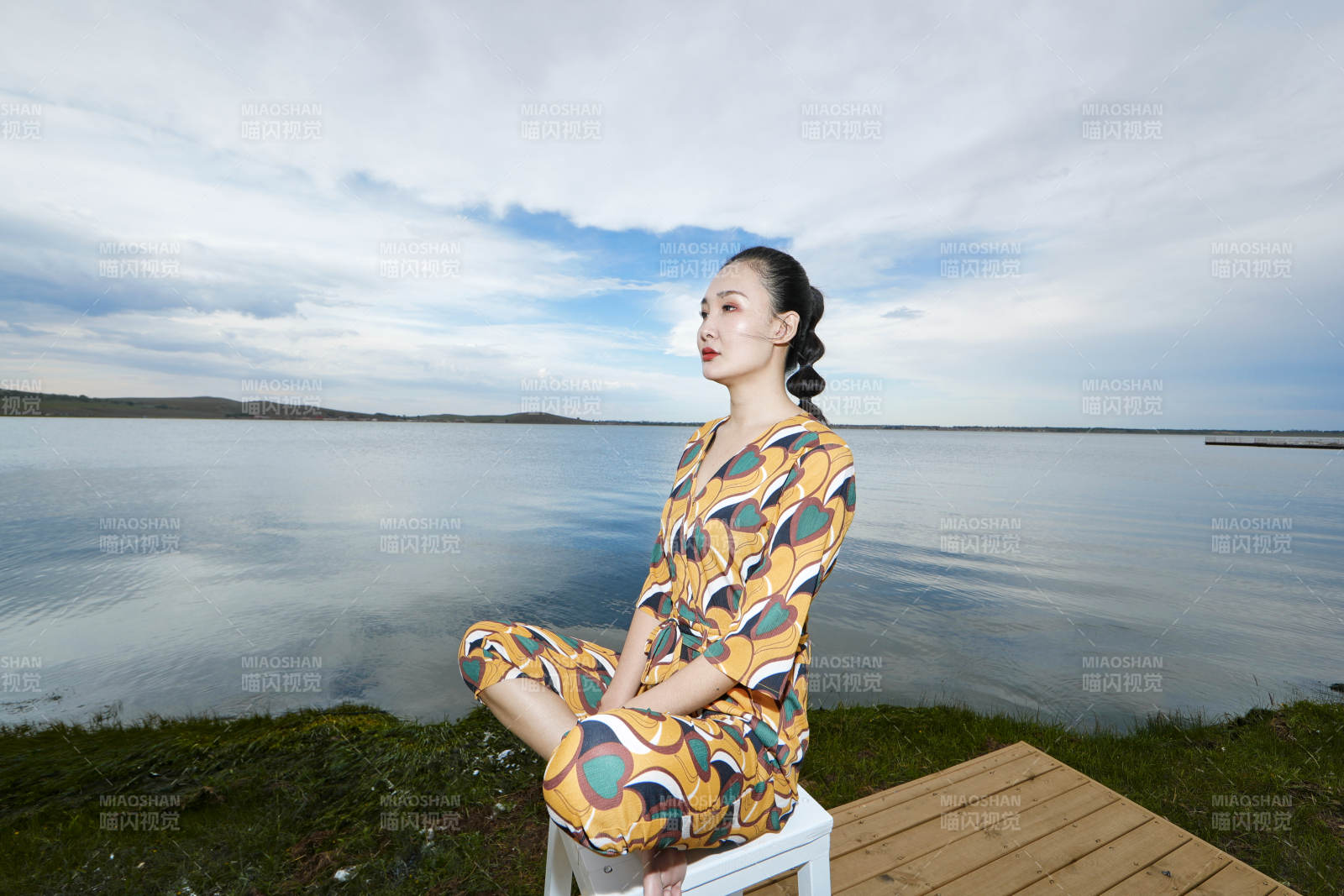 悠閑的坐在美麗湖岸碼頭的亞洲年輕女性人像