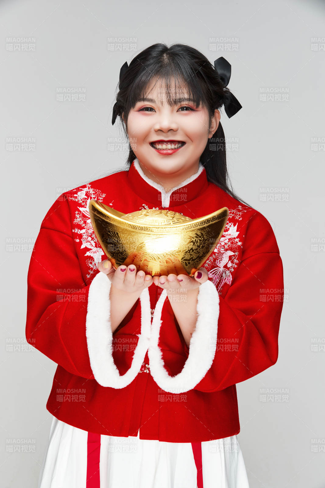 手捧金元寶身穿喜慶漢服的可愛少女
