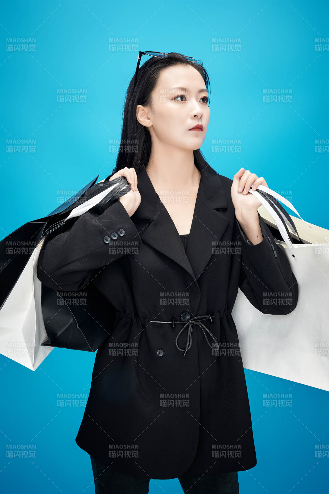 青藍色背景下手提購物袋的亞洲時尚少女