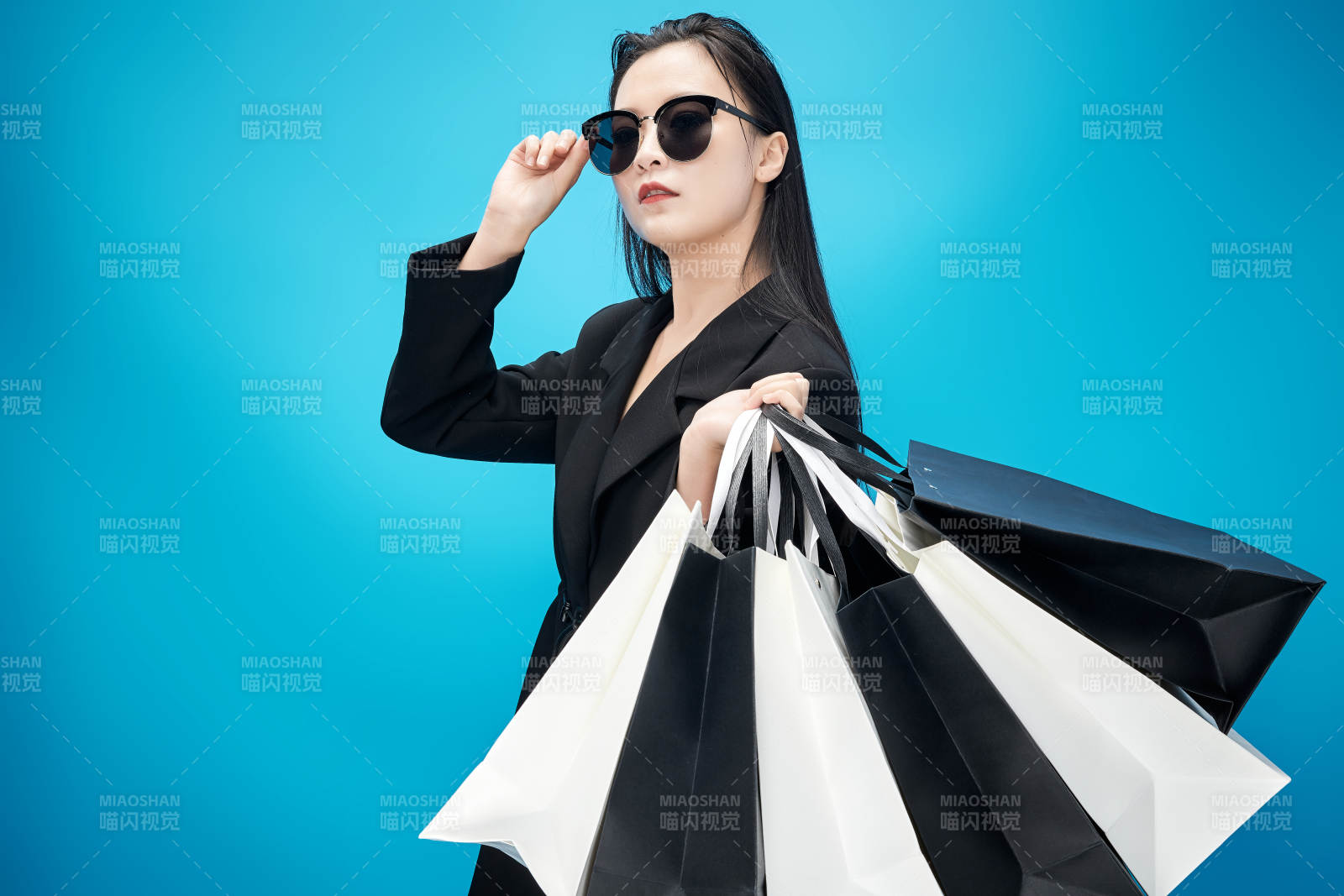 青藍色背景下手提購物袋的亞洲時尚少女