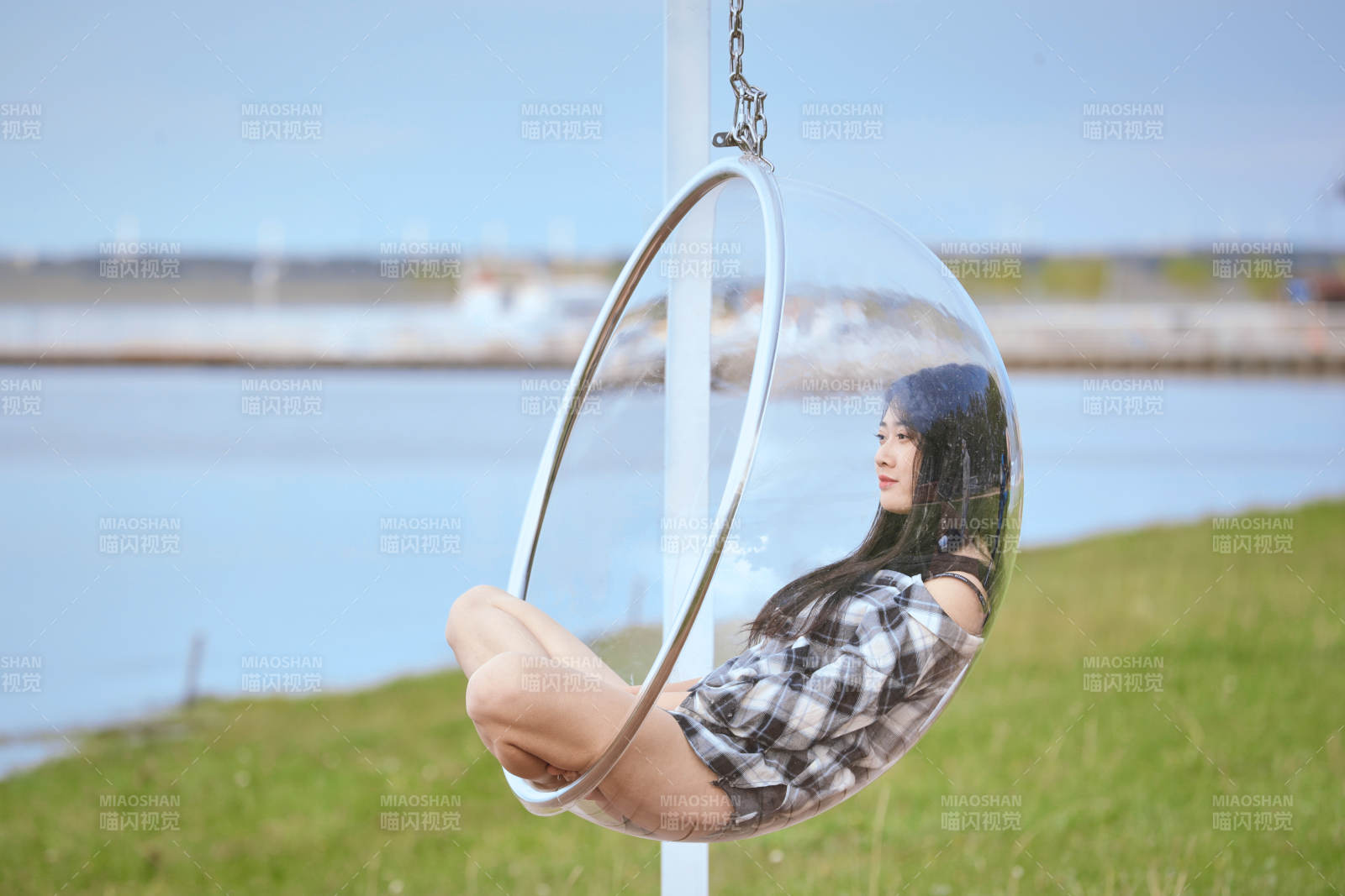 草原湖畔坐在透明秋千里的亞洲年輕女性人像