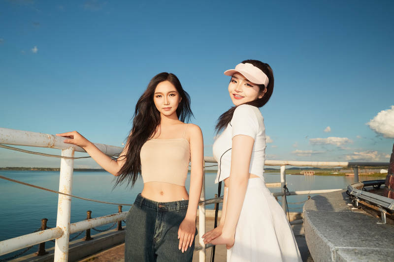 盛夏在景区湖边灯塔上拍照游玩的美女们