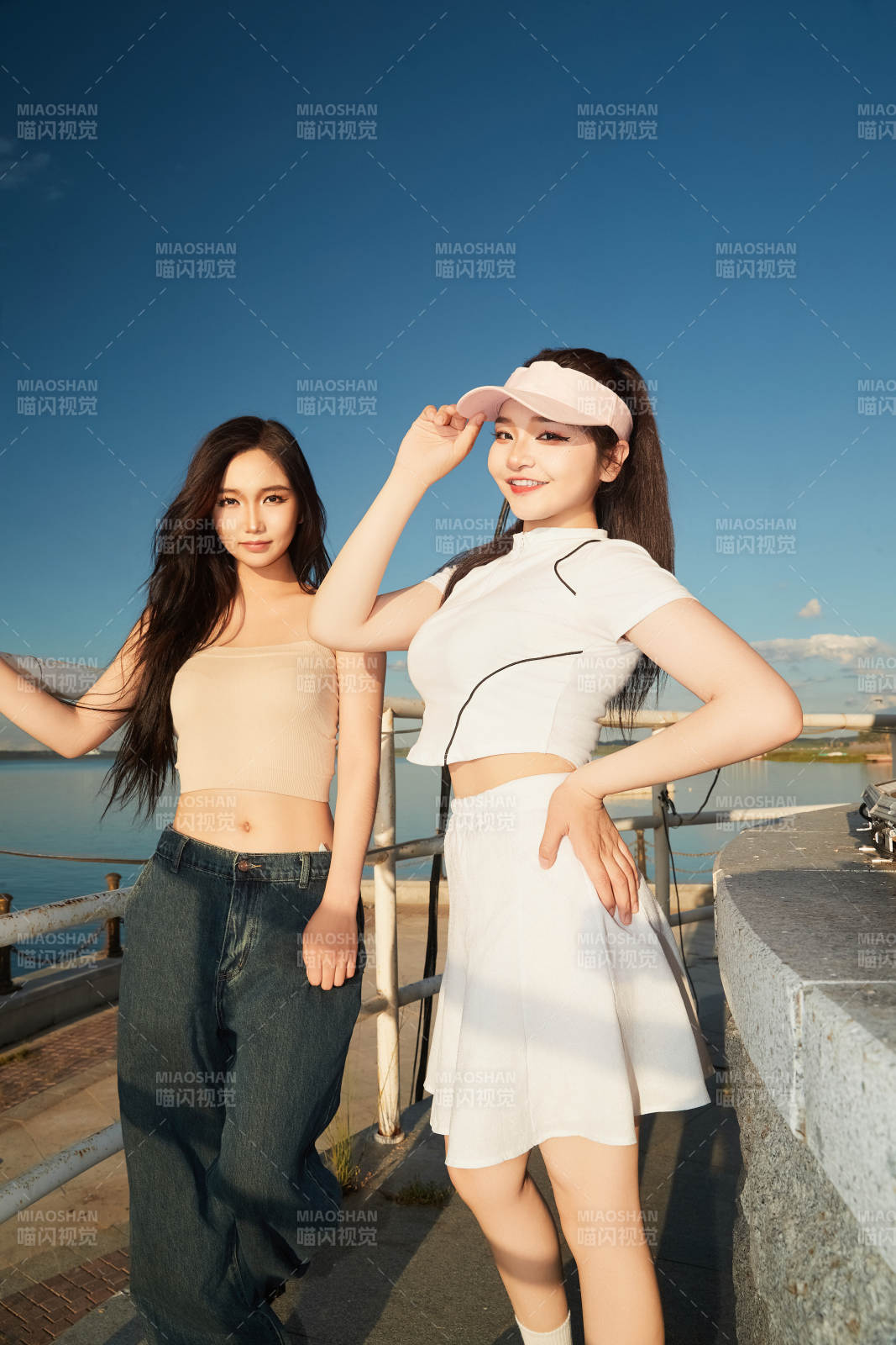 盛夏在景區湖邊燈塔上拍照游玩的美女們