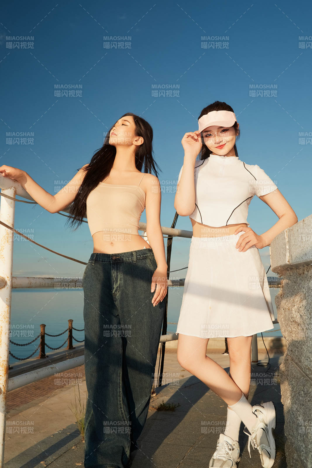 盛夏在景區湖邊燈塔上拍照游玩的美女們