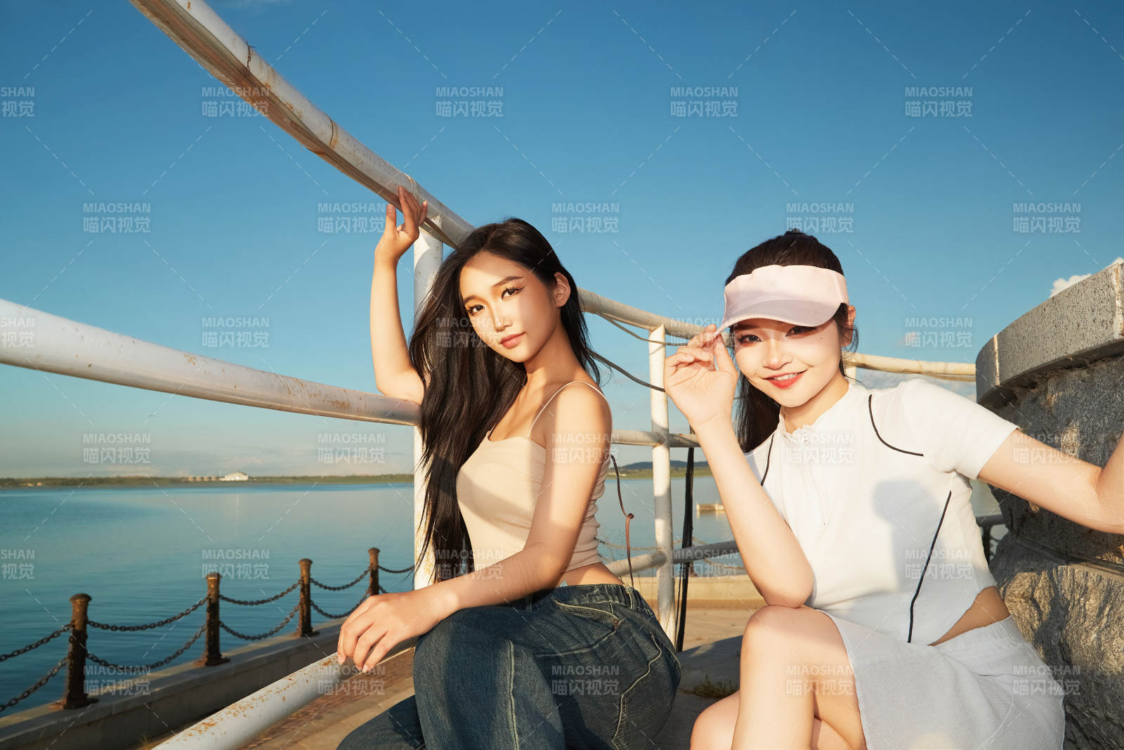 盛夏在景區(qū)湖邊燈塔上拍照游玩的美女們