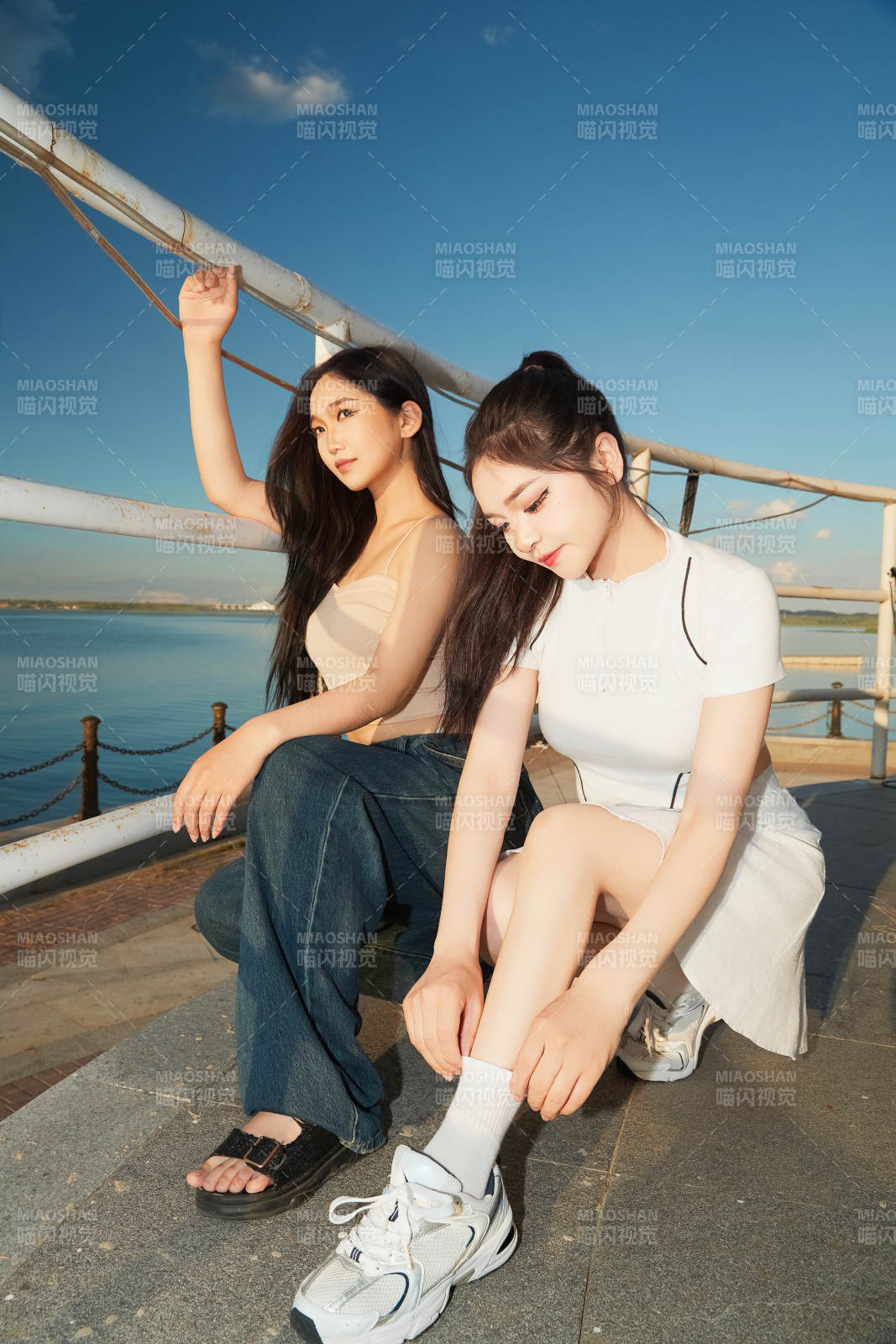 盛夏在景区湖边灯塔上拍照游玩的美女们图片