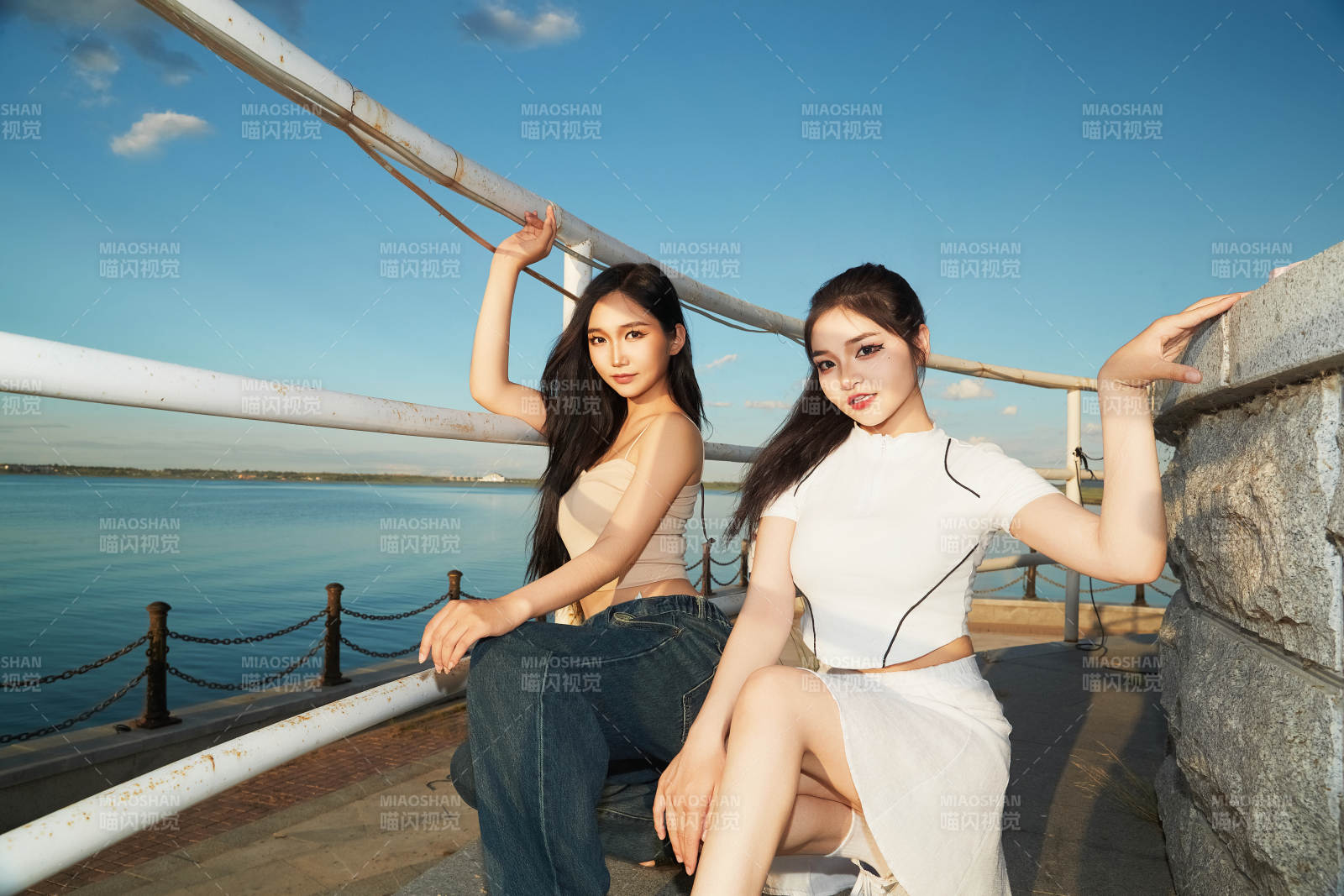 盛夏在景區(qū)湖邊燈塔上拍照游玩的美女們