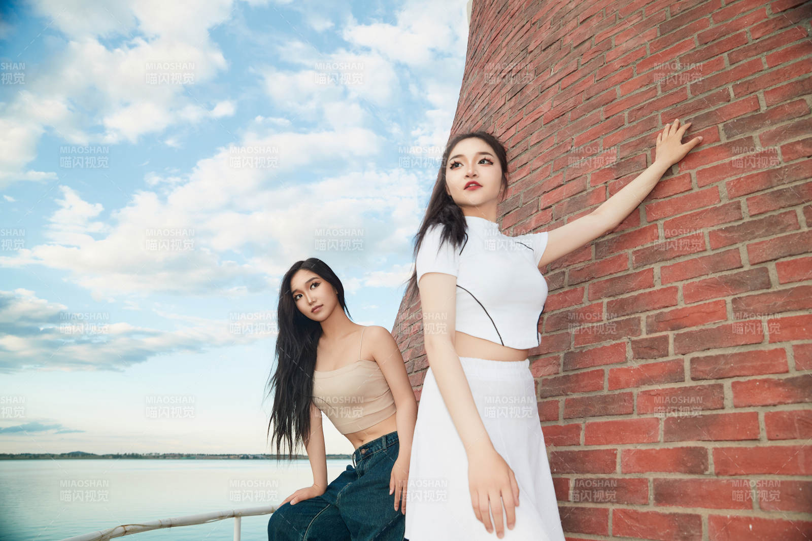 盛夏在景区湖边灯塔上拍照游玩的美女们图片