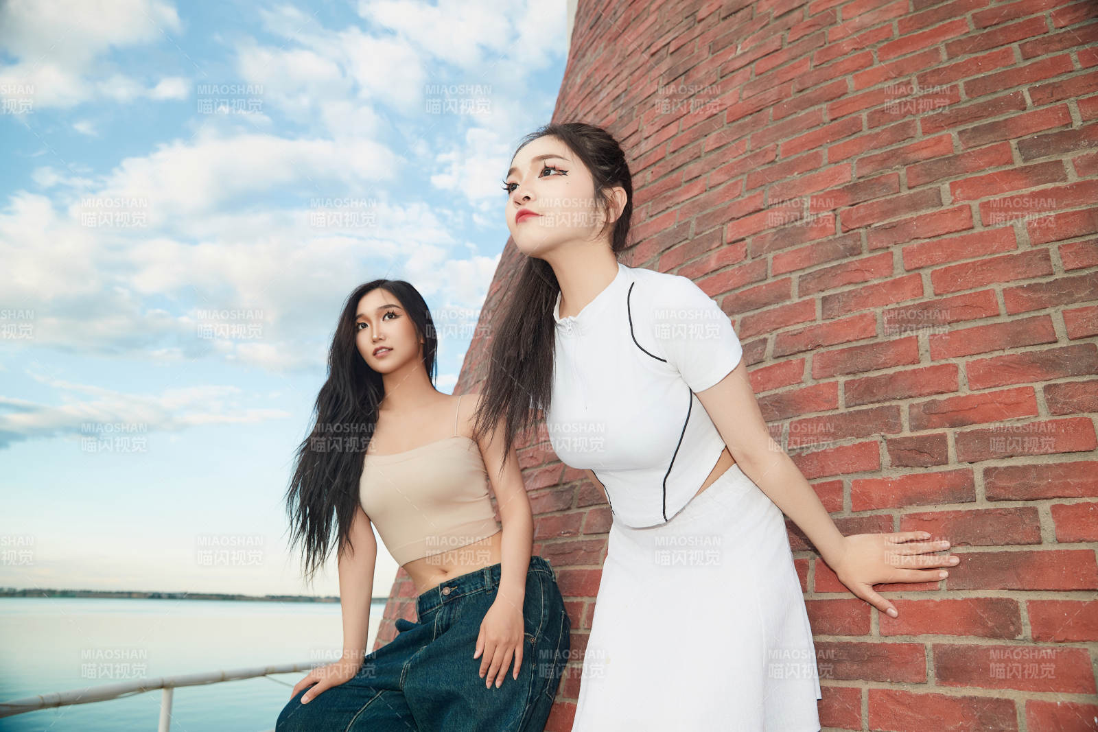 盛夏在景區(qū)湖邊燈塔上拍照游玩的美女們