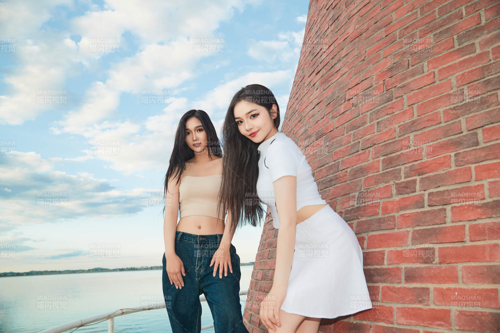 盛夏在景区湖边灯塔上拍照游玩的美女们图片