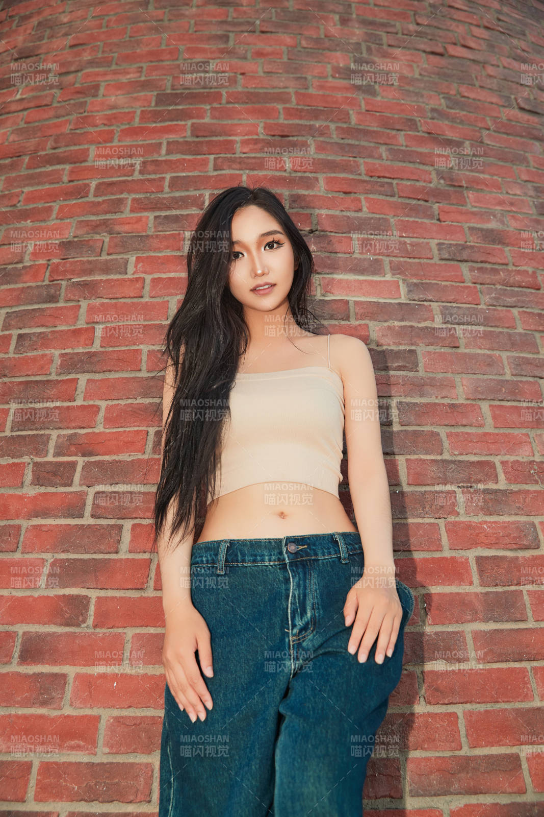 盛夏在景區湖邊燈塔上拍照游玩的美女