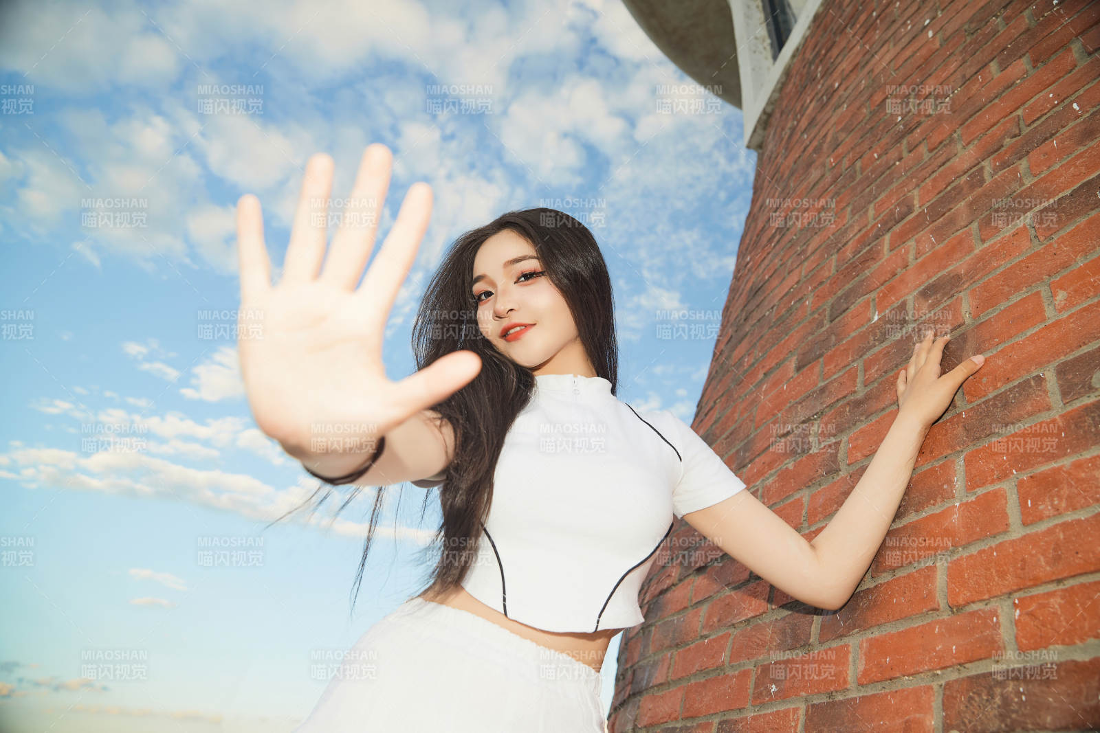 盛夏在景區(qū)湖邊燈塔上拍照游玩的美女