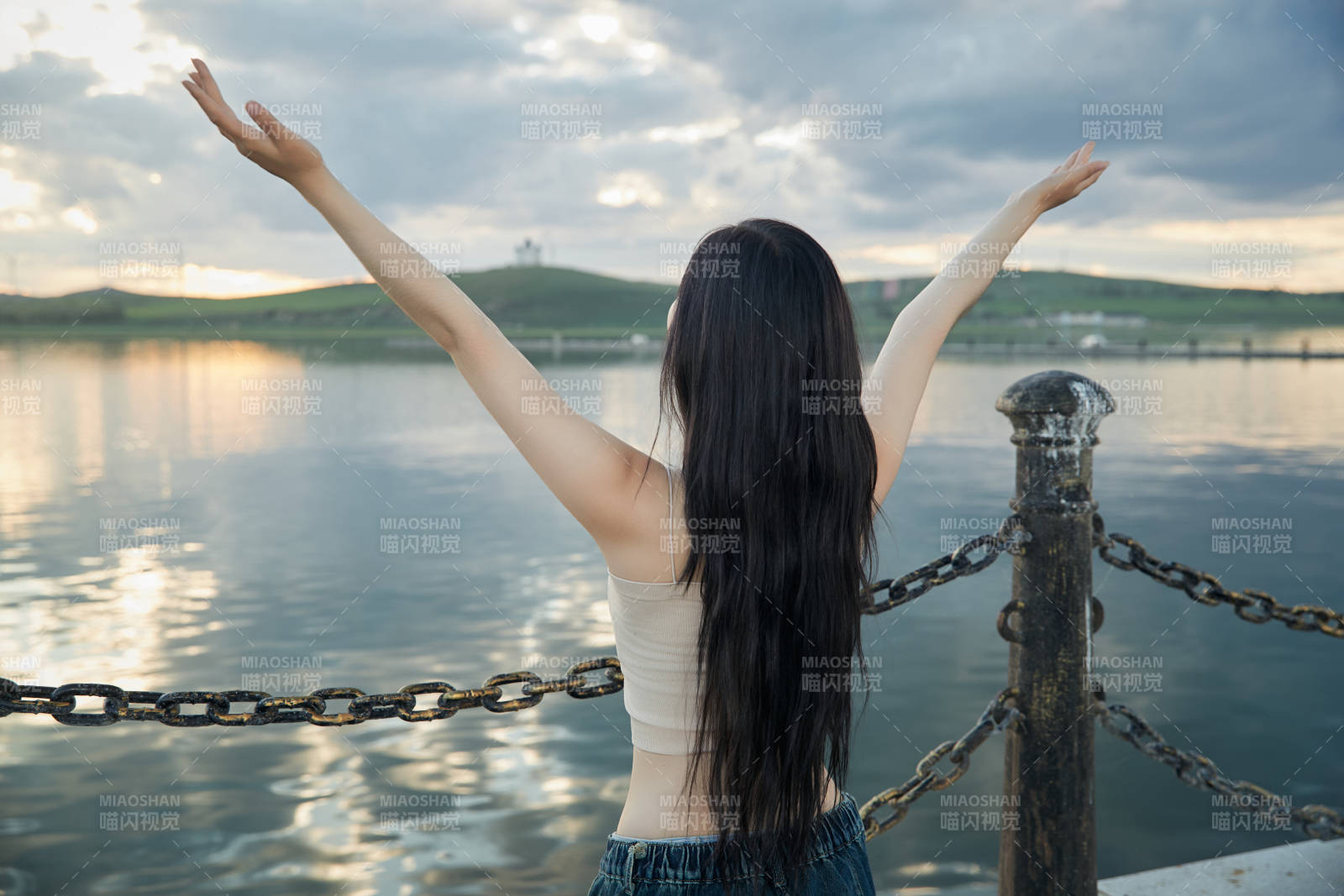 傍晚在湖邊欣賞風景拍照的亞洲美女