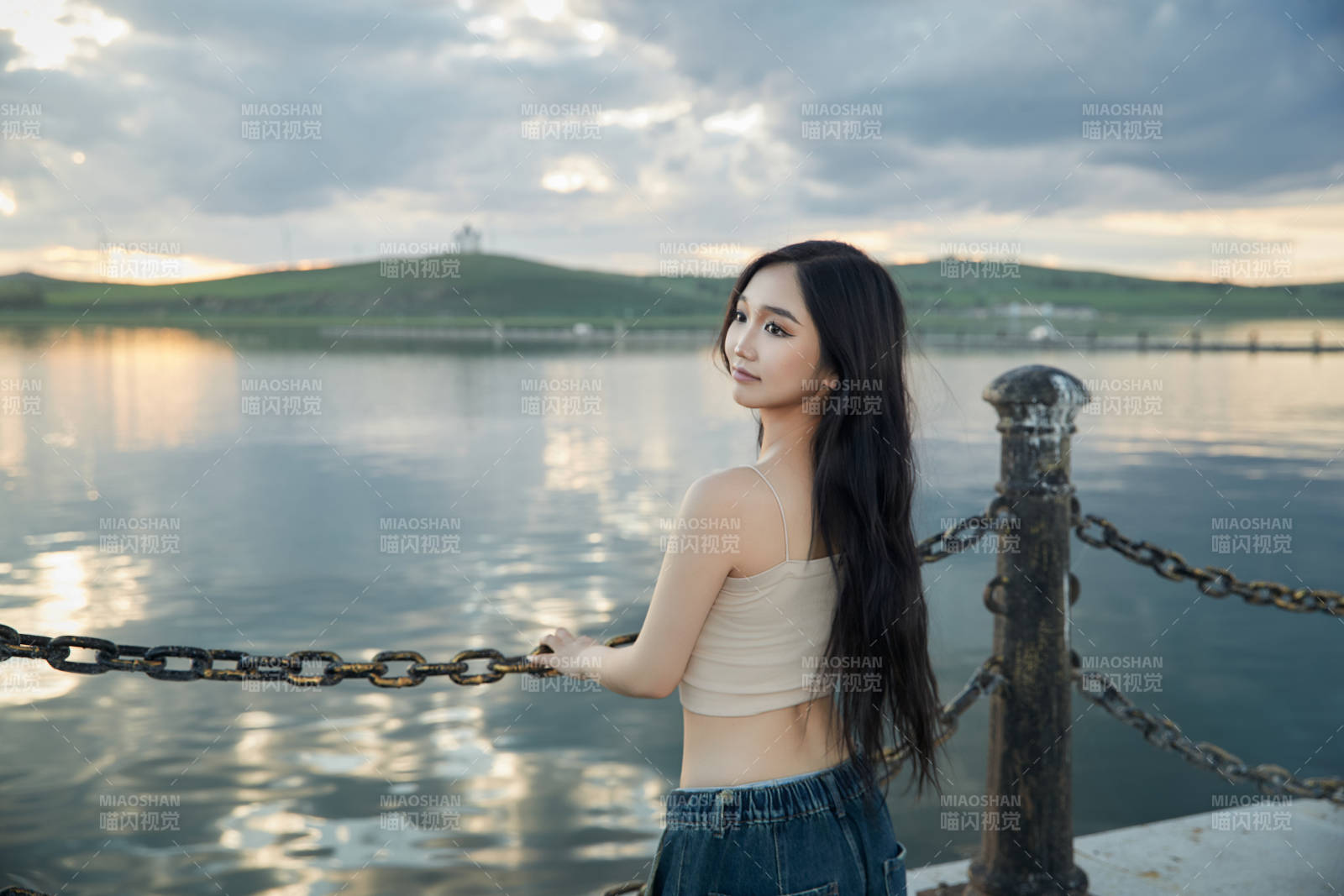 傍晚在湖邊欣賞風(fēng)景拍照的亞洲美女