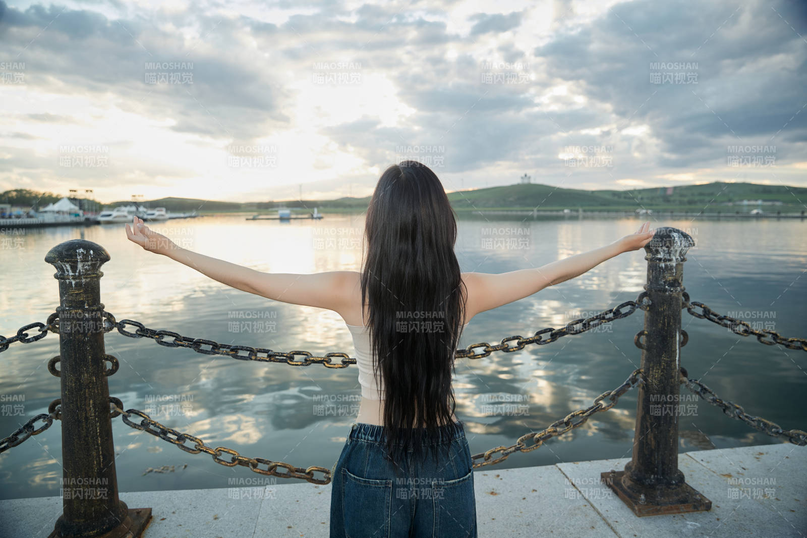 傍晚在湖边欣赏风景拍照的亚洲美女