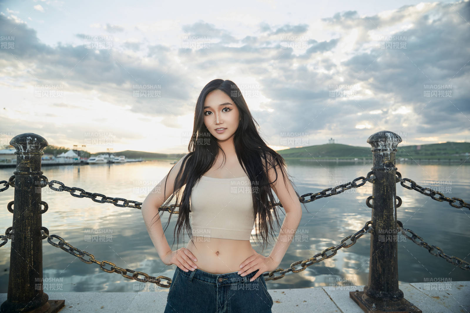 傍晚在湖边欣赏风景拍照的亚洲美女图片