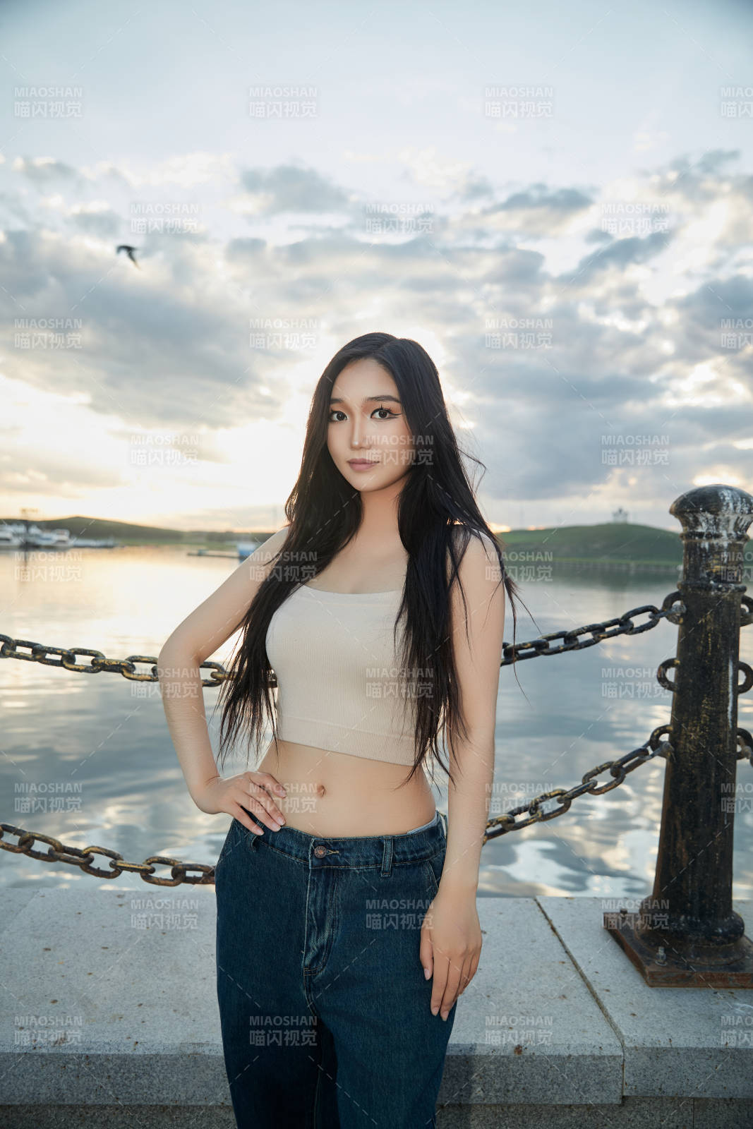 傍晚在湖邊欣賞風(fēng)景拍照的亞洲美女