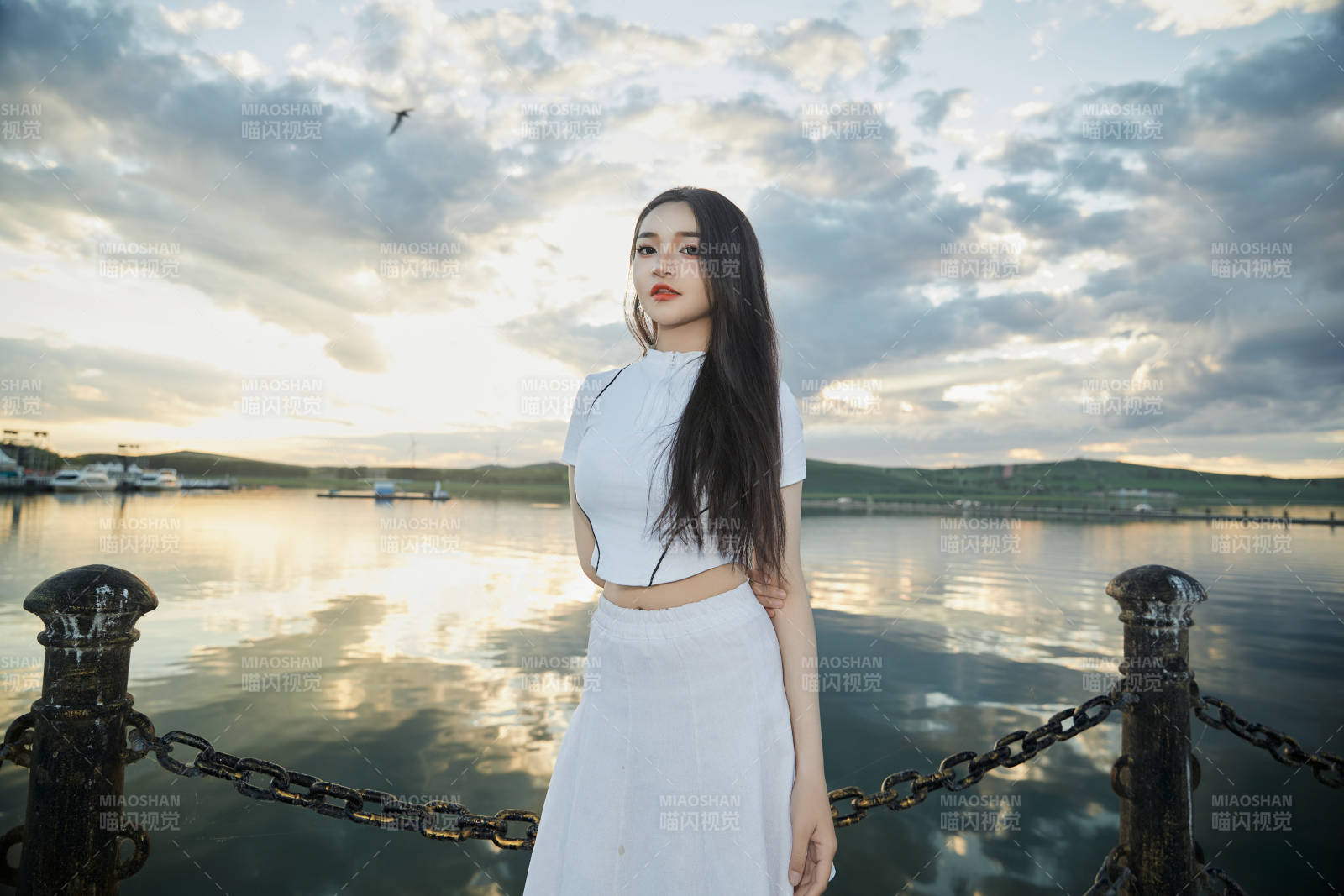 傍晚在湖边欣赏风景拍照的亚洲美女