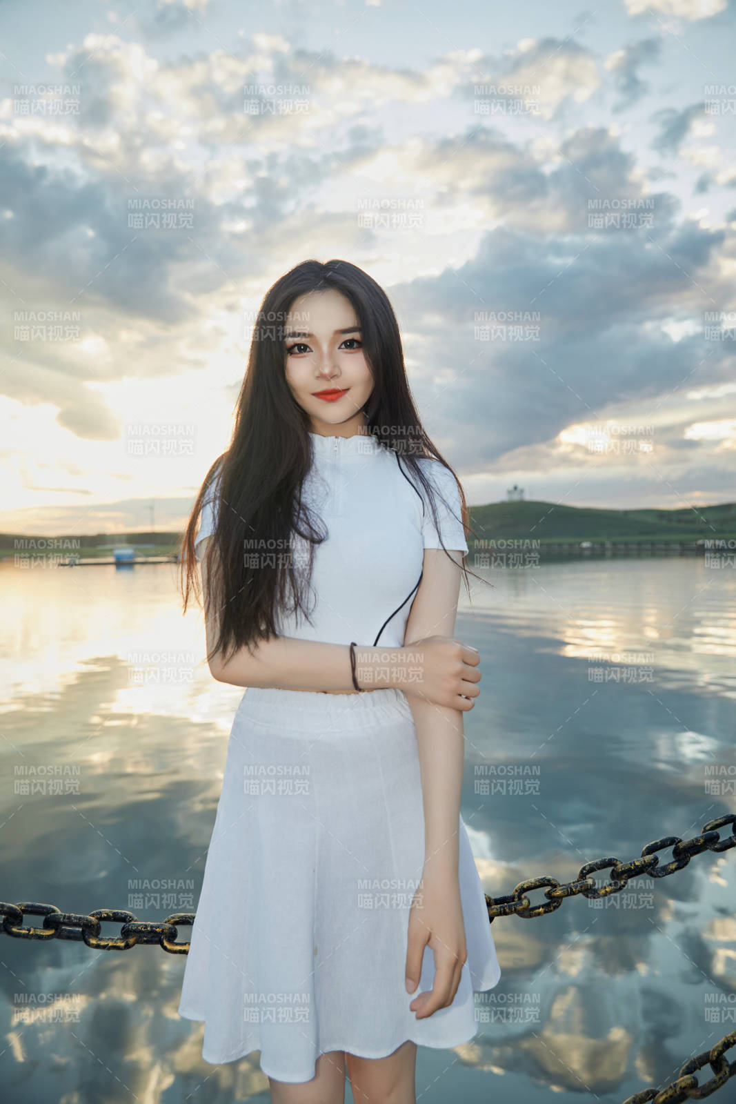 傍晚在湖边欣赏风景拍照的亚洲美女