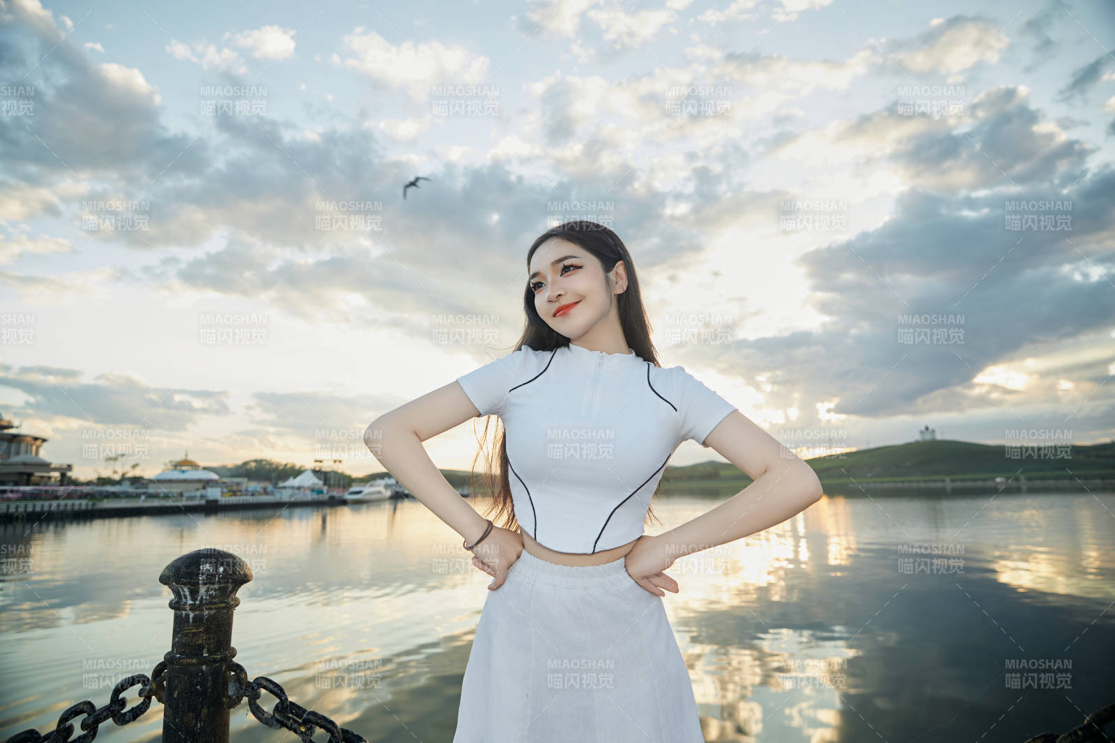 傍晚在湖邊欣賞風(fēng)景拍照的亞洲美女