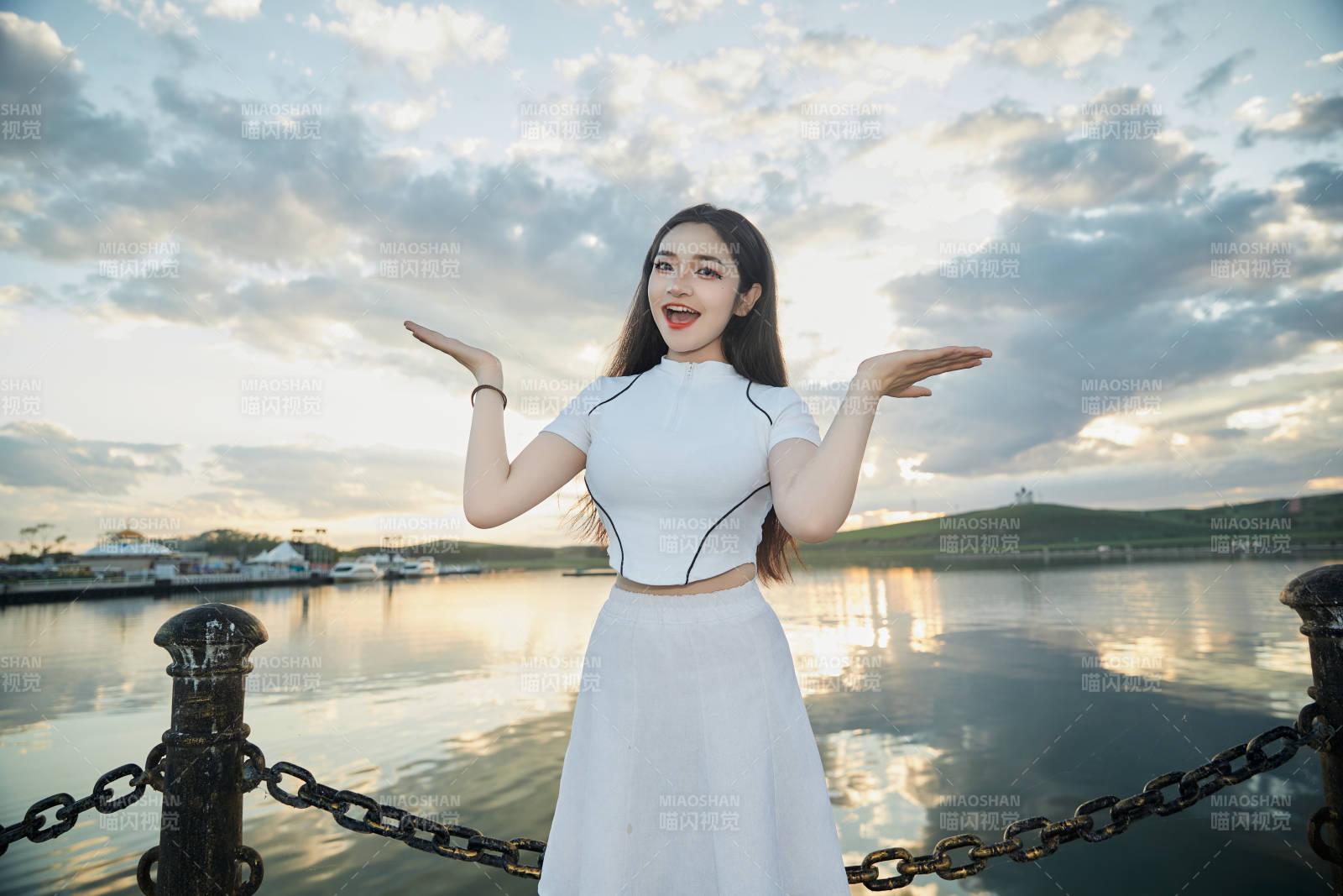 傍晚在湖边欣赏风景拍照的亚洲美女