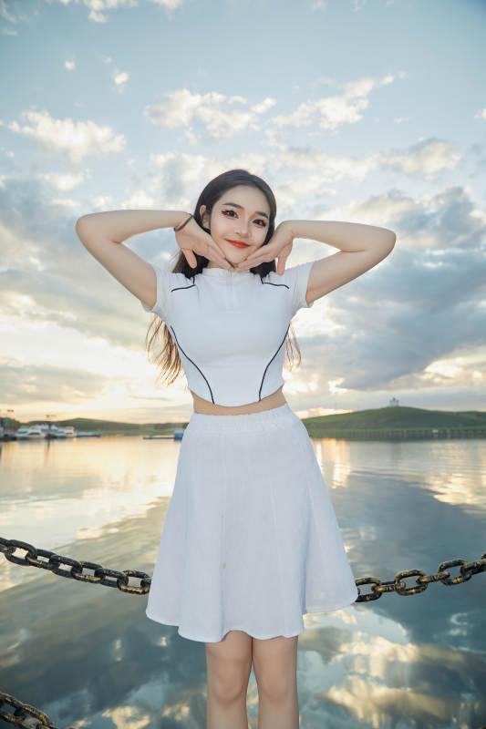 傍晚在湖边欣赏风景拍照的亚洲美女